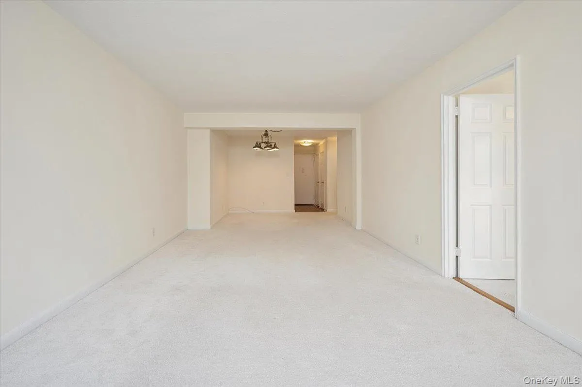 Spare room featuring carpet flooring and a chandelier Spare room featuring carpet flooring and a chandelier