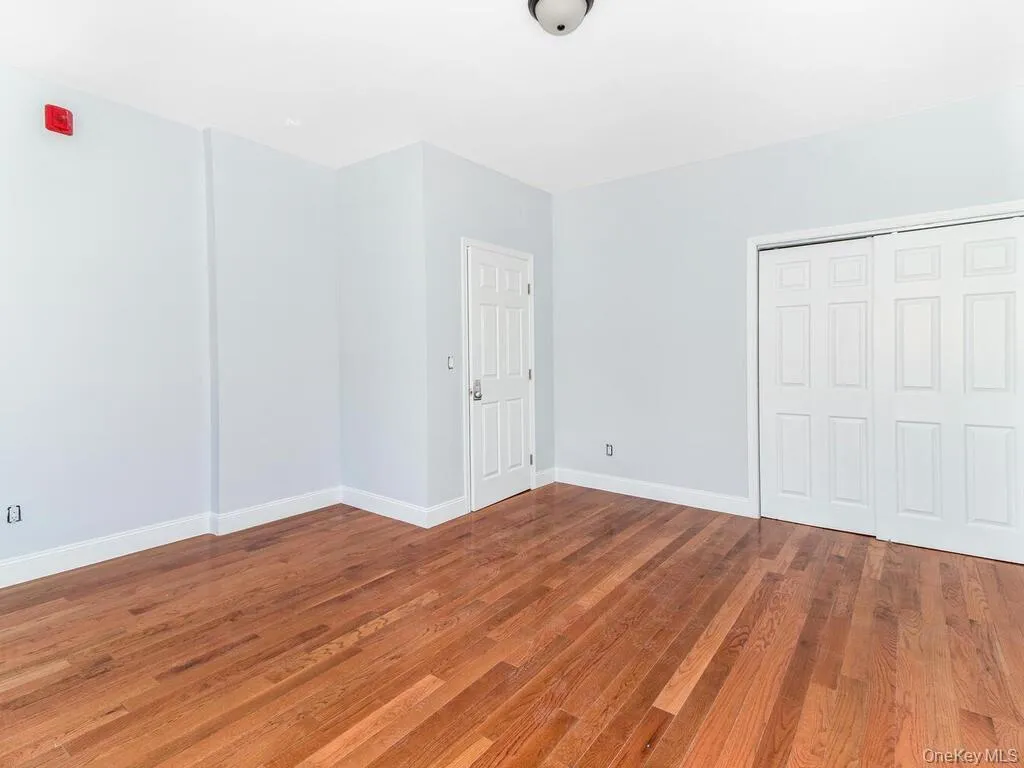 Unfurnished bedroom featuring a closet, baseboards, and wood finished floors Unfurnished bedroom featuring a closet, baseboards, and wood finished floors