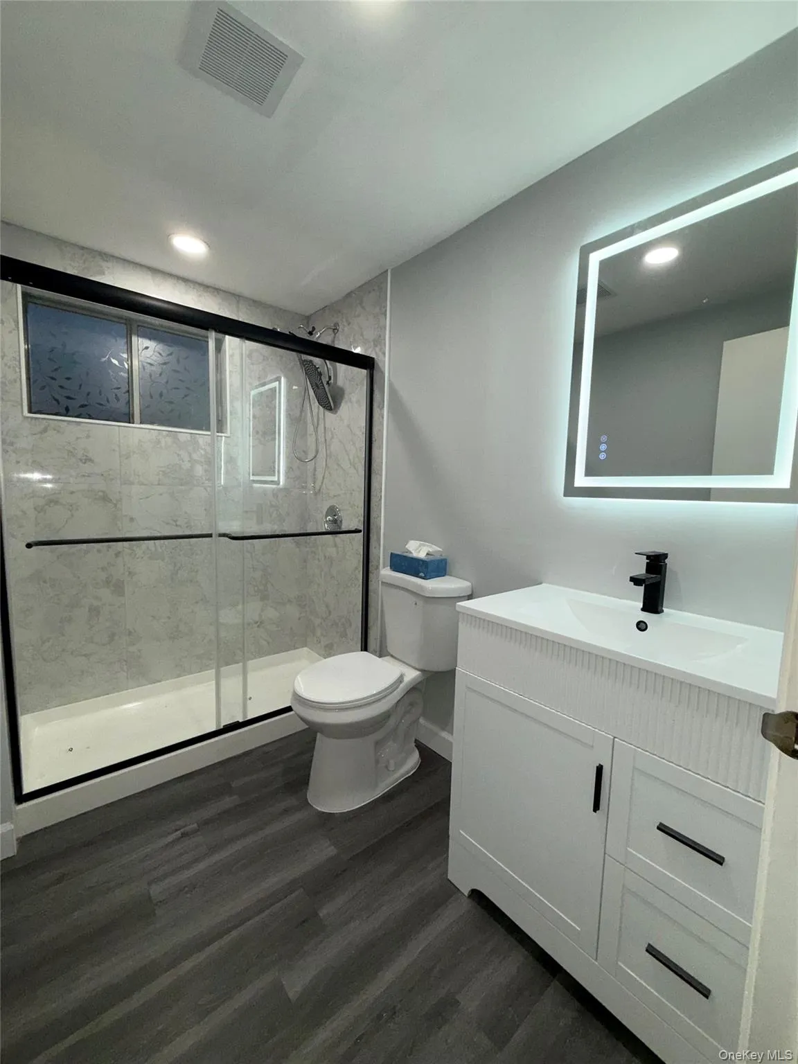 Bathroom with vanity, a shower stall, dark wood finished floors, and recessed lighting Bathroom with vanity, a shower stall, dark wood finished floors, and recessed lighting