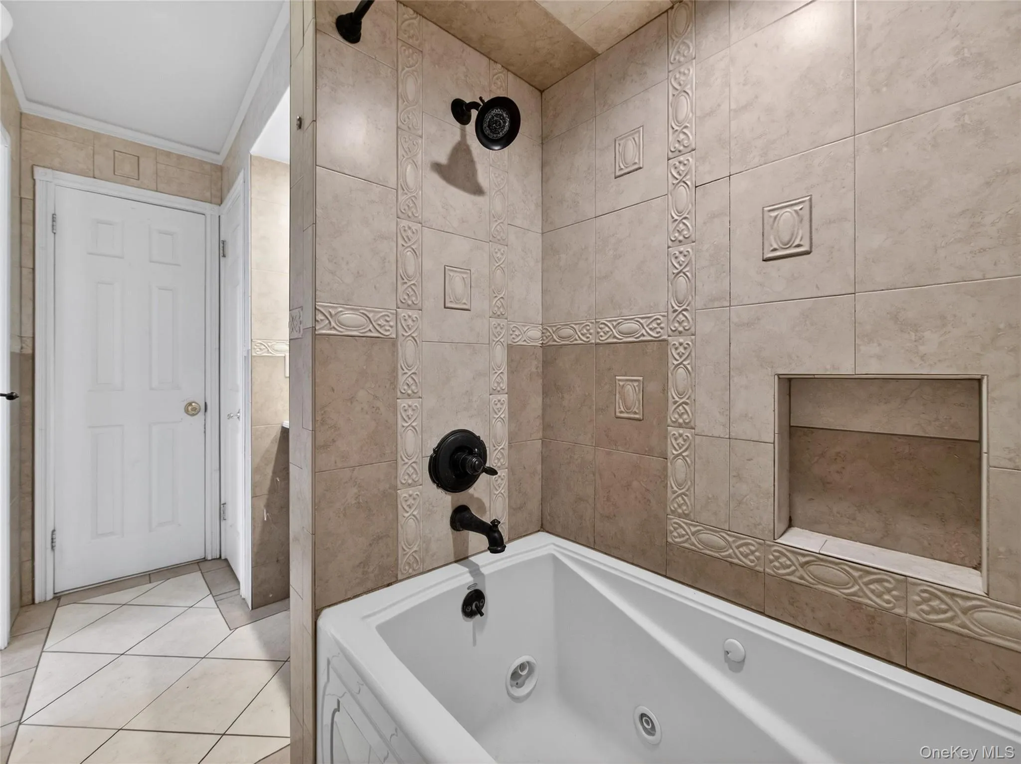 Full bathroom featuring light tile patterned floors and tile walls Full bathroom featuring light tile patterned floors and tile walls