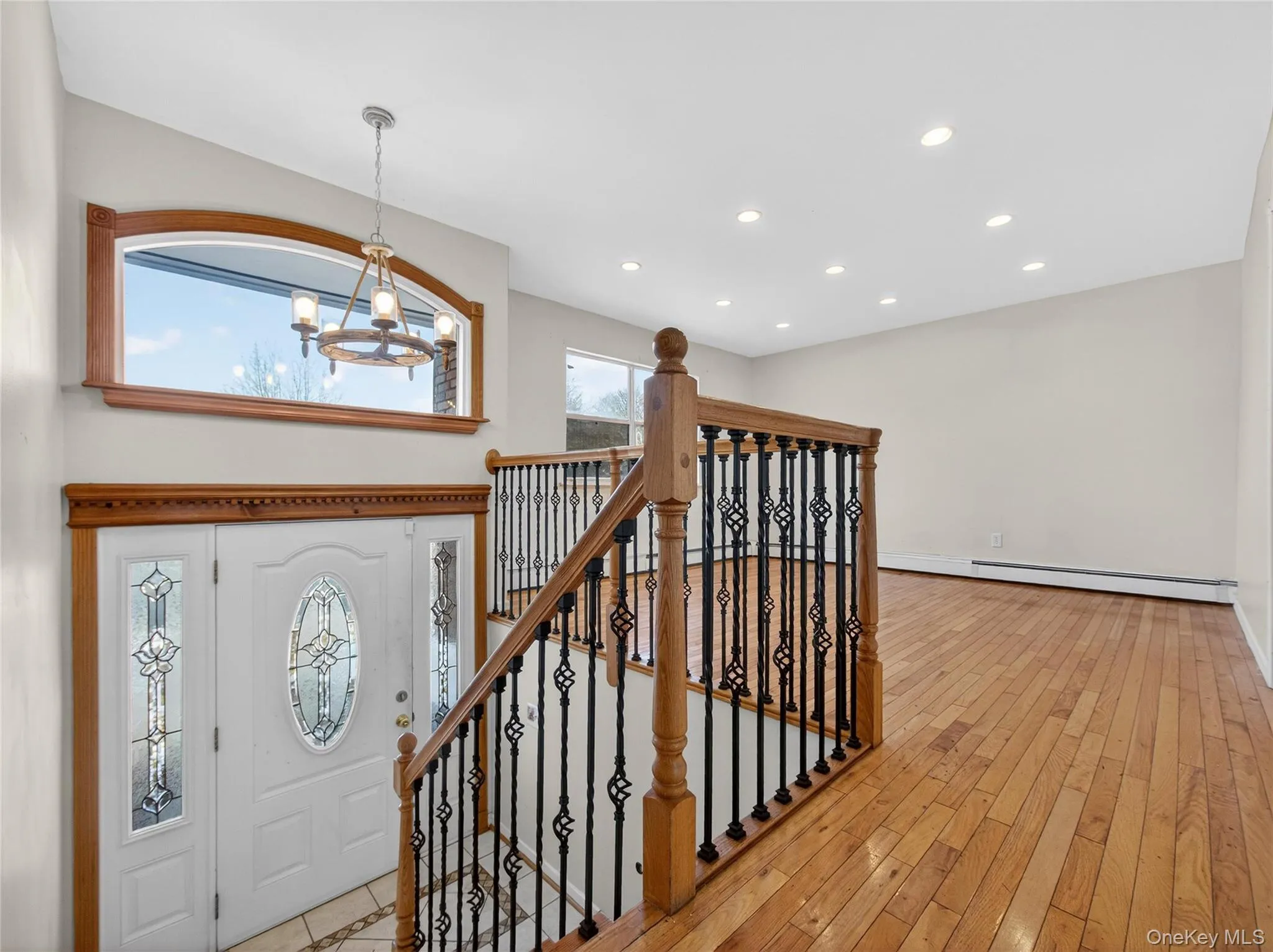 Entrance foyer featuring a chandelier, recessed lighting, a baseboard radiator, and light wood finished floors Entrance foyer featuring a chandelier, recessed lighting, a baseboard radiator, and light wood finished floors