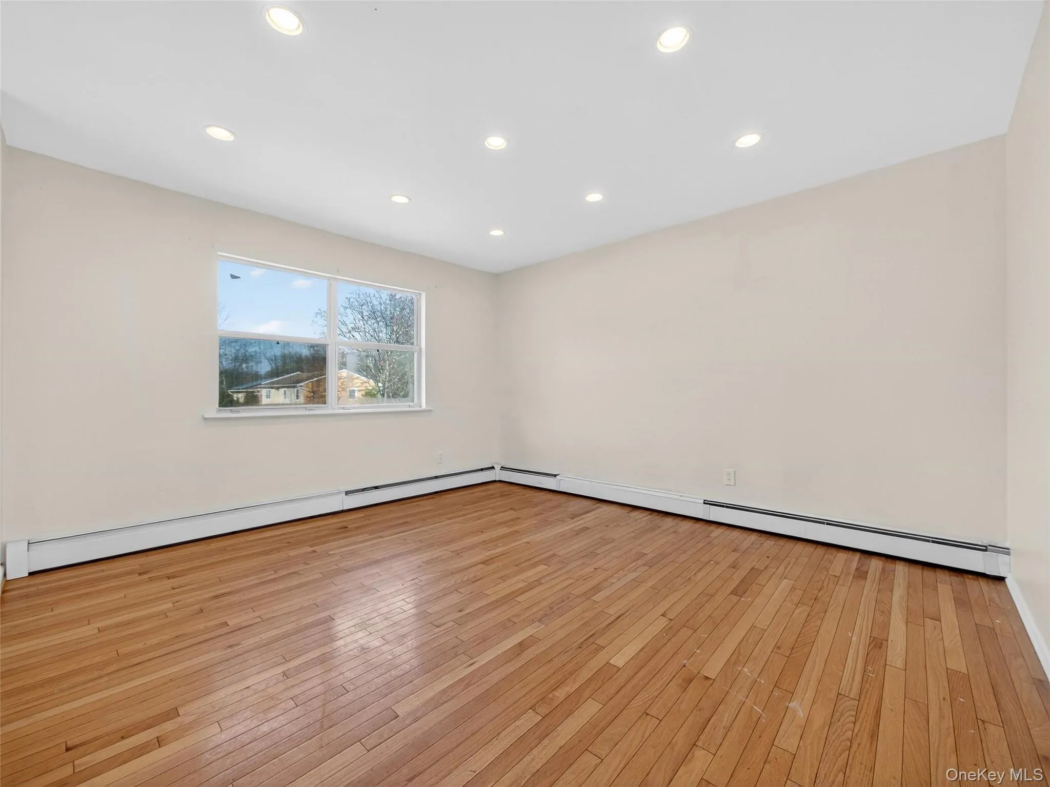 Spare room with light wood-style floors, a baseboard heating unit, and recessed lighting Spare room with light wood-style floors, a baseboard heating unit, and recessed lighting