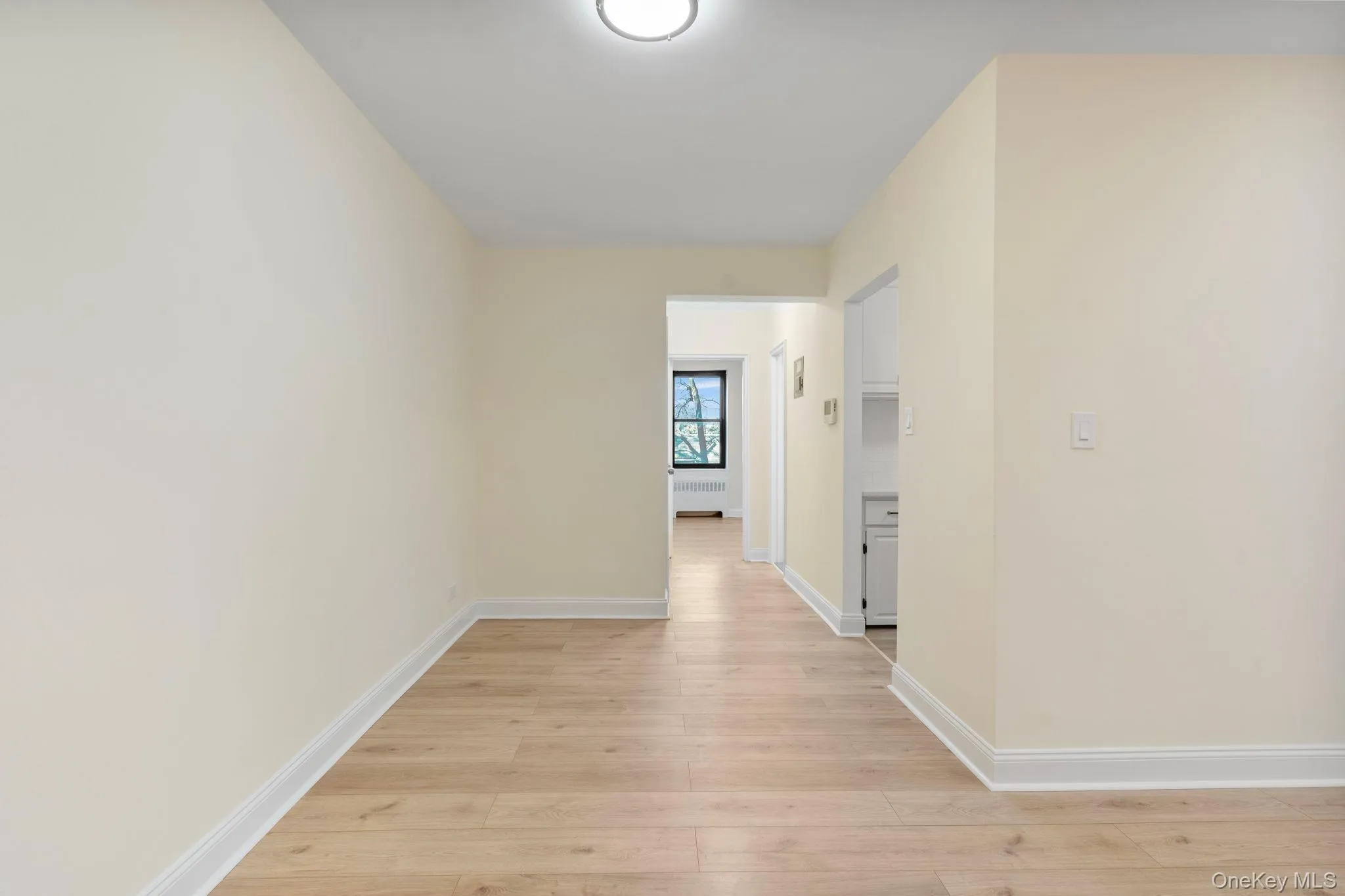 Dining area and hallway with light wood flooring and radiator Dining area and hallway with light wood flooring and radiator