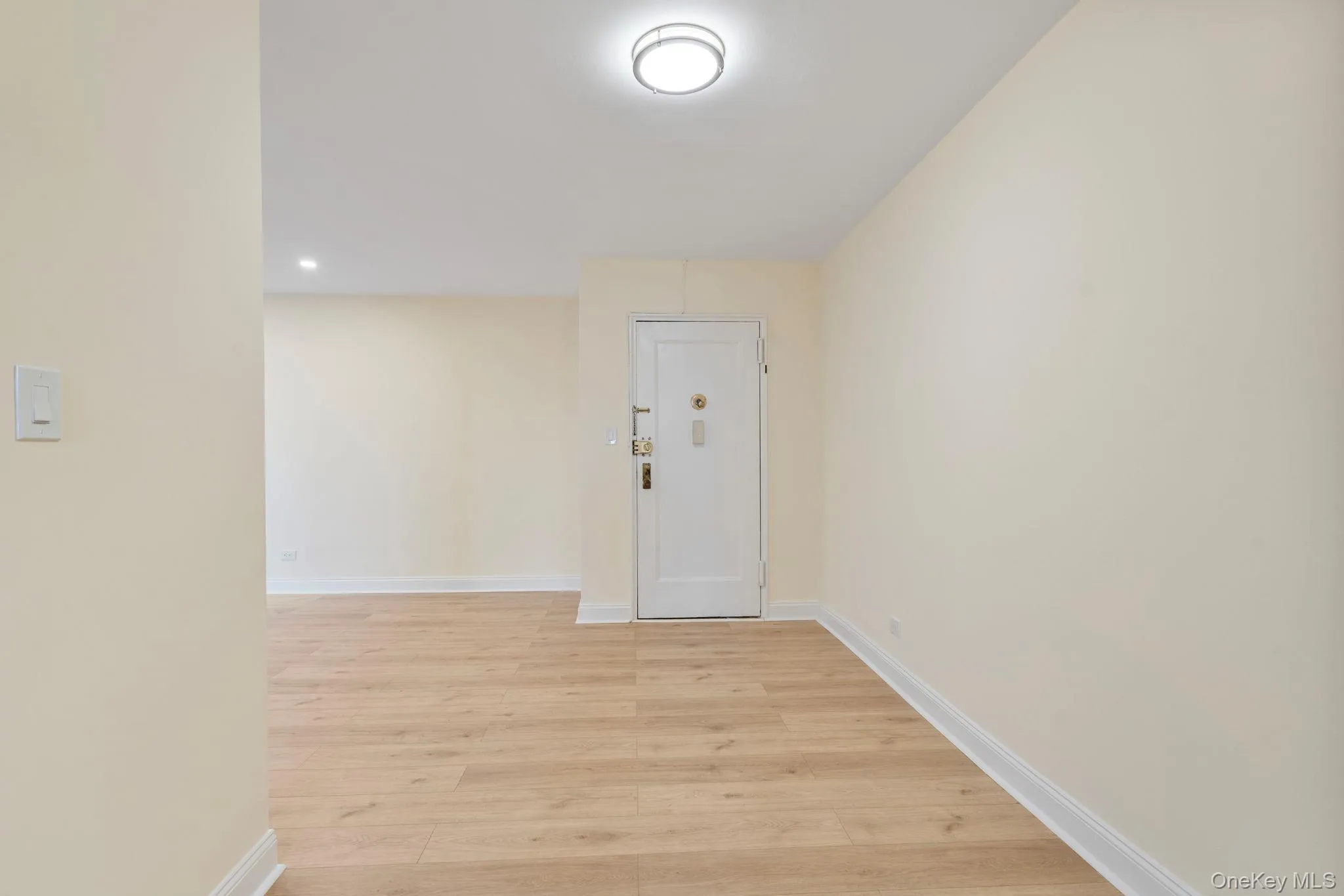 Entry hallway with light wood floors and recessed lighting Entry hallway with light wood floors and recessed lighting