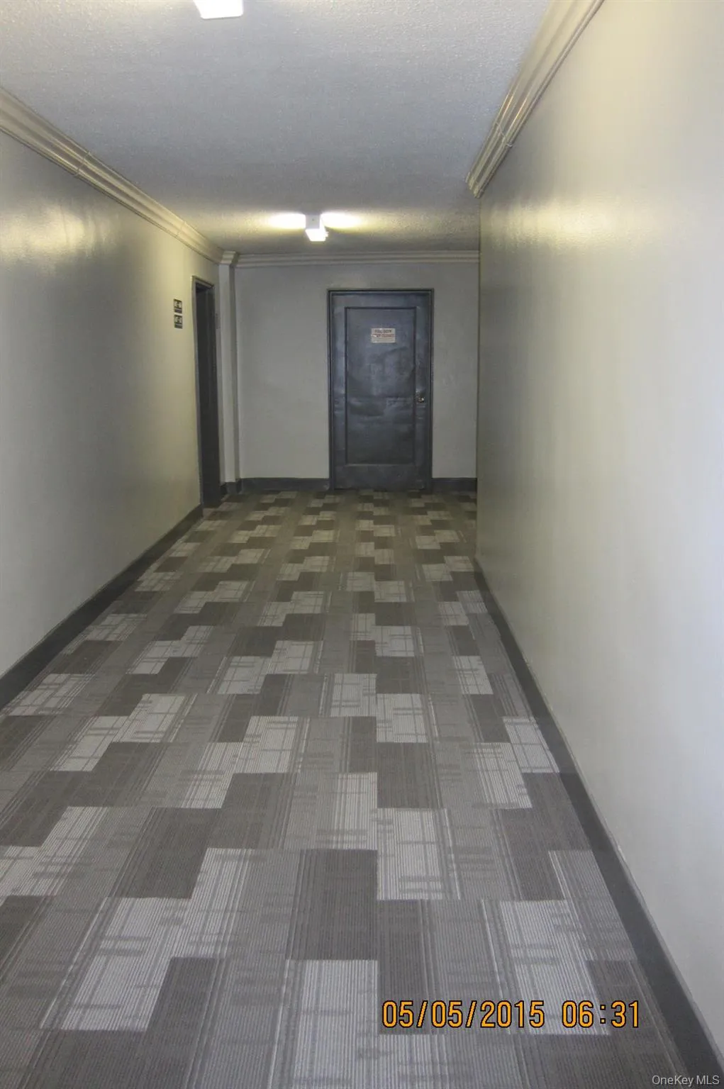 Common area hallway featuring a textured ceiling and ornamental molding Common area hallway featuring a textured ceiling and ornamental molding