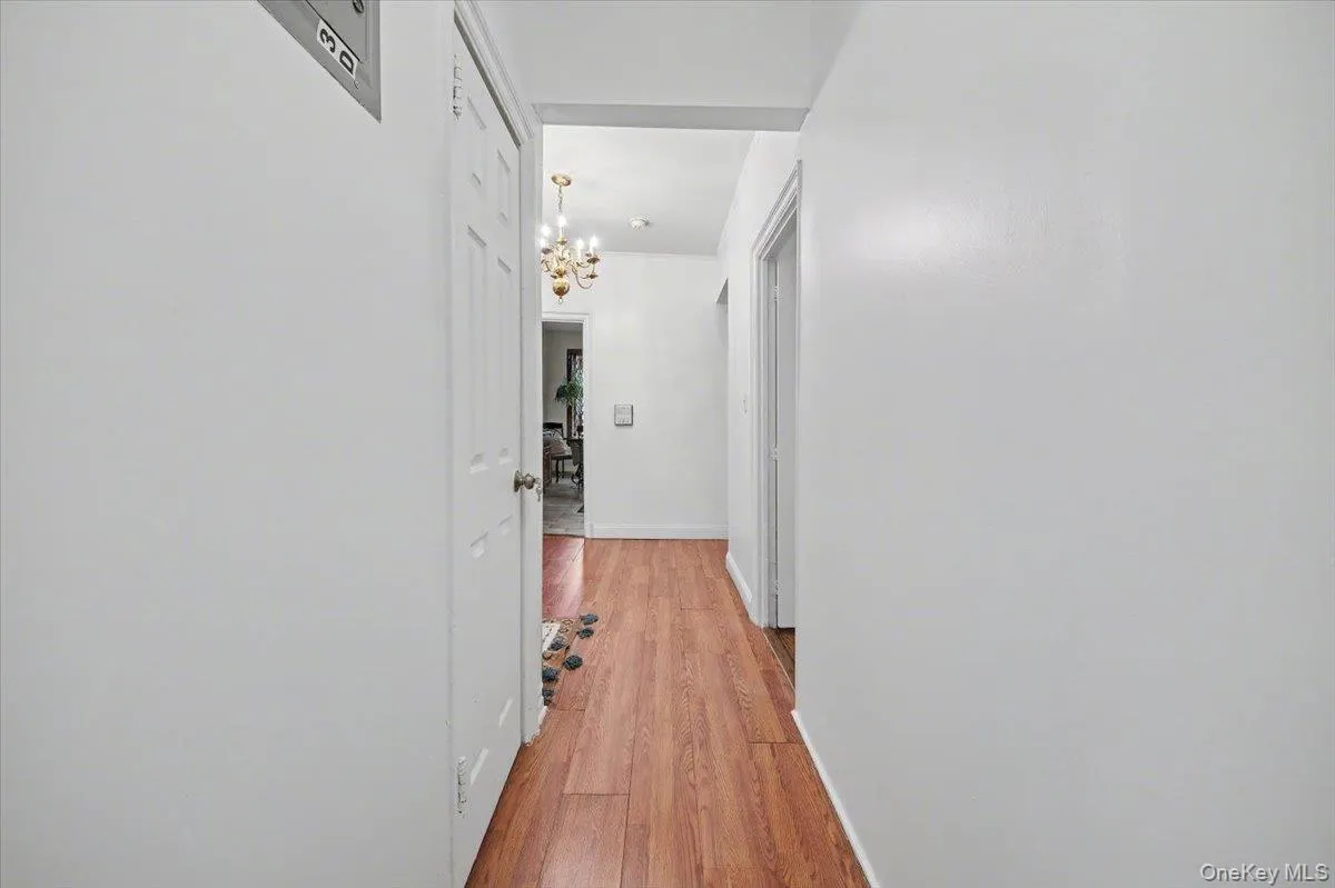 Hall with a chandelier and light wood-style floors Hall with a chandelier and light wood-style floors