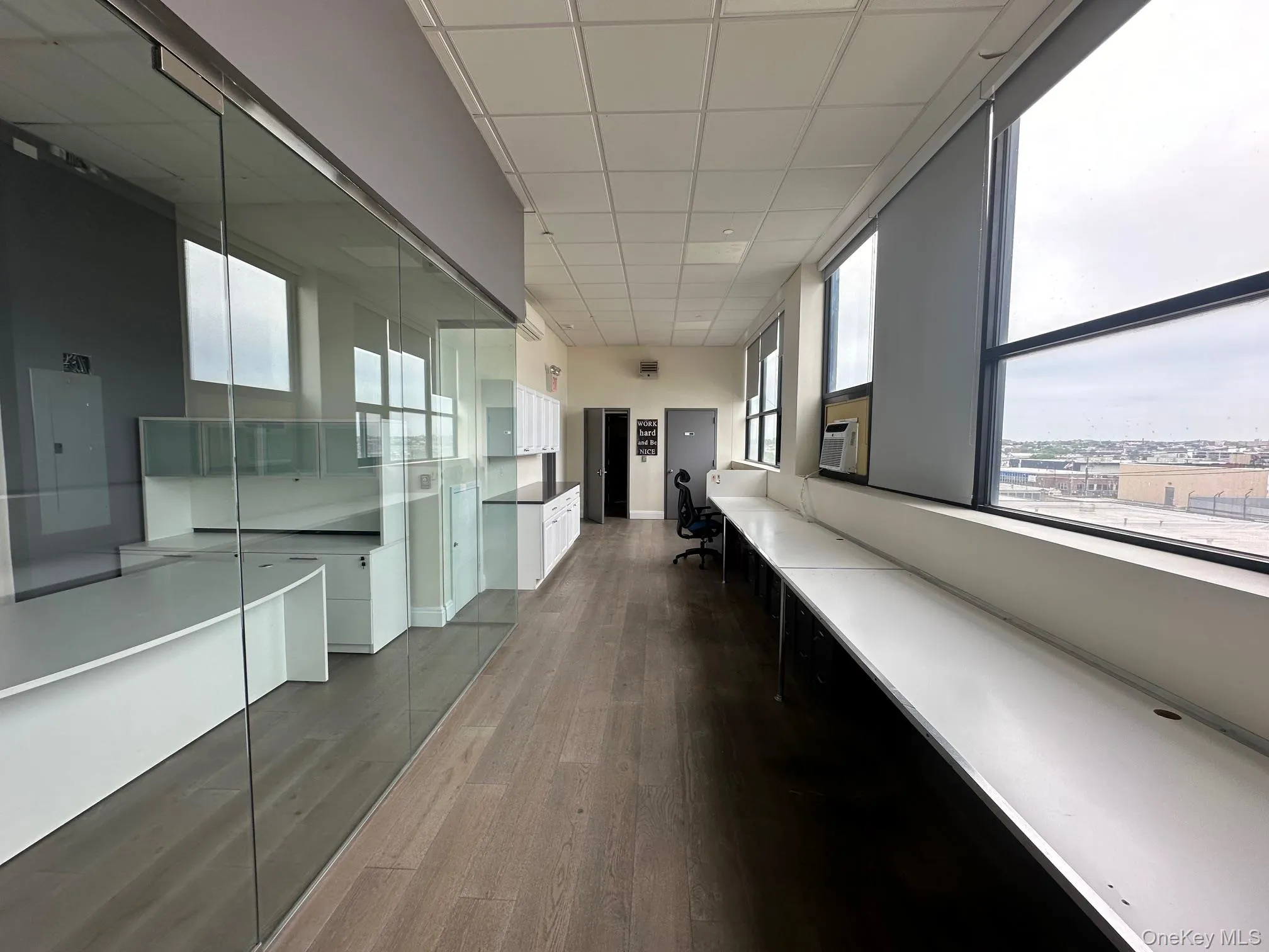 Corridor featuring a drop ceiling, dark wood-style floors, and electric panel Corridor featuring a drop ceiling, dark wood-style floors, and electric panel
