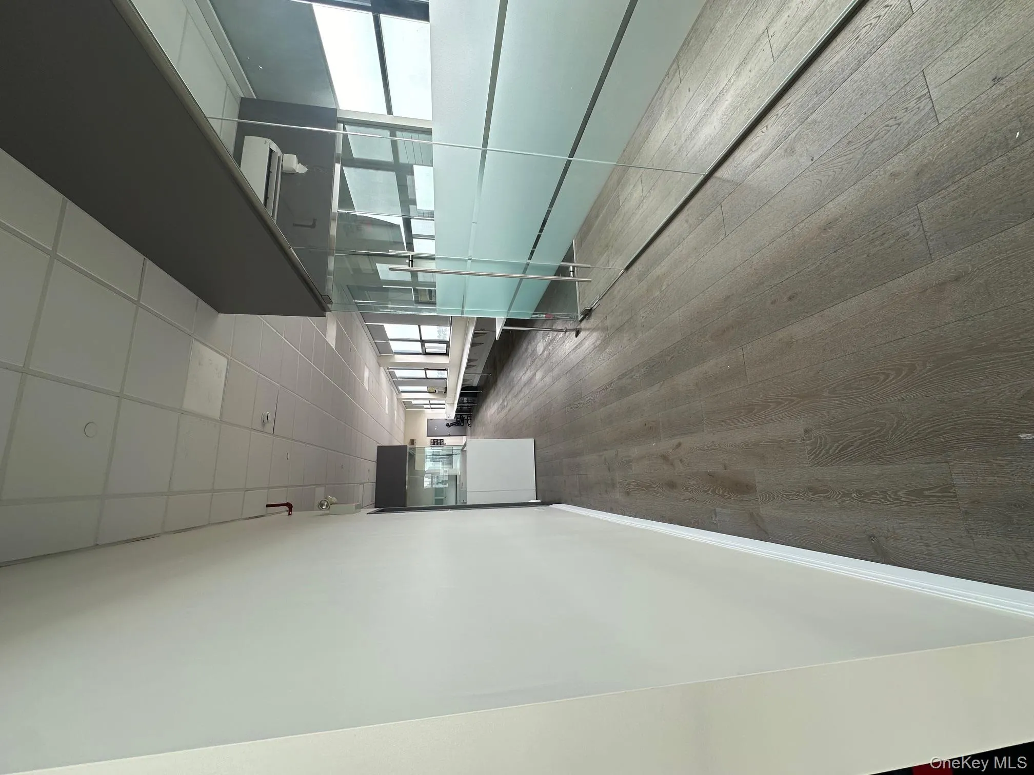 Hall with a drop ceiling and dark wood-style flooring Hall with a drop ceiling and dark wood-style flooring