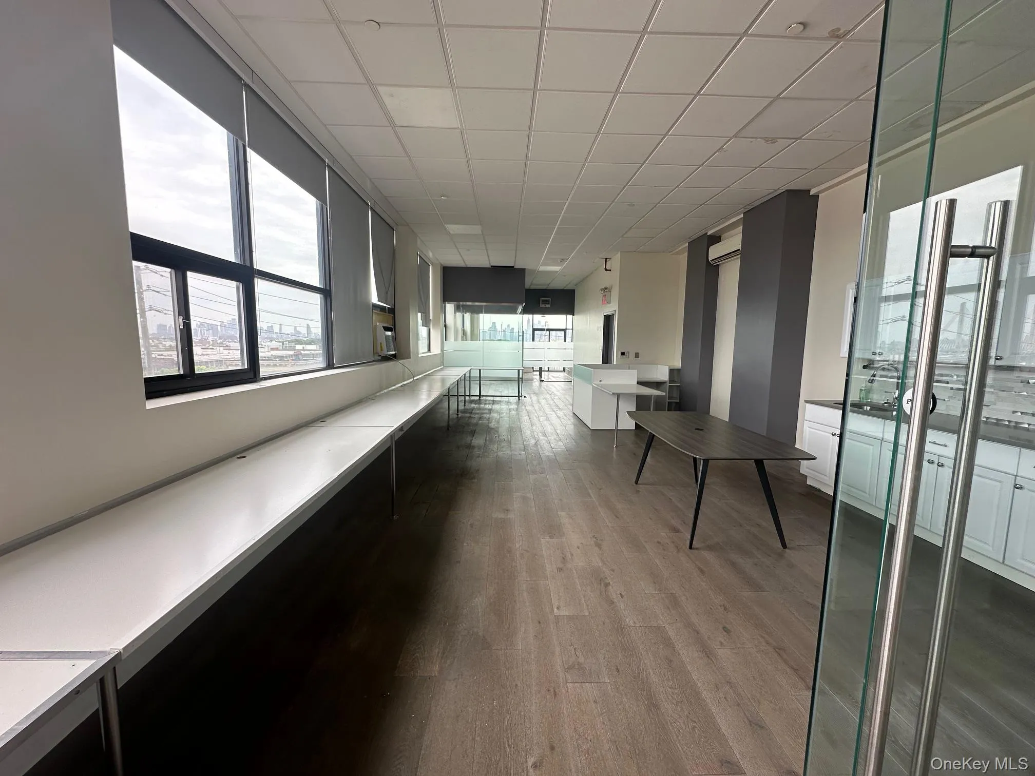 Hall featuring light wood finished floors and a paneled ceiling Hall featuring light wood finished floors and a paneled ceiling