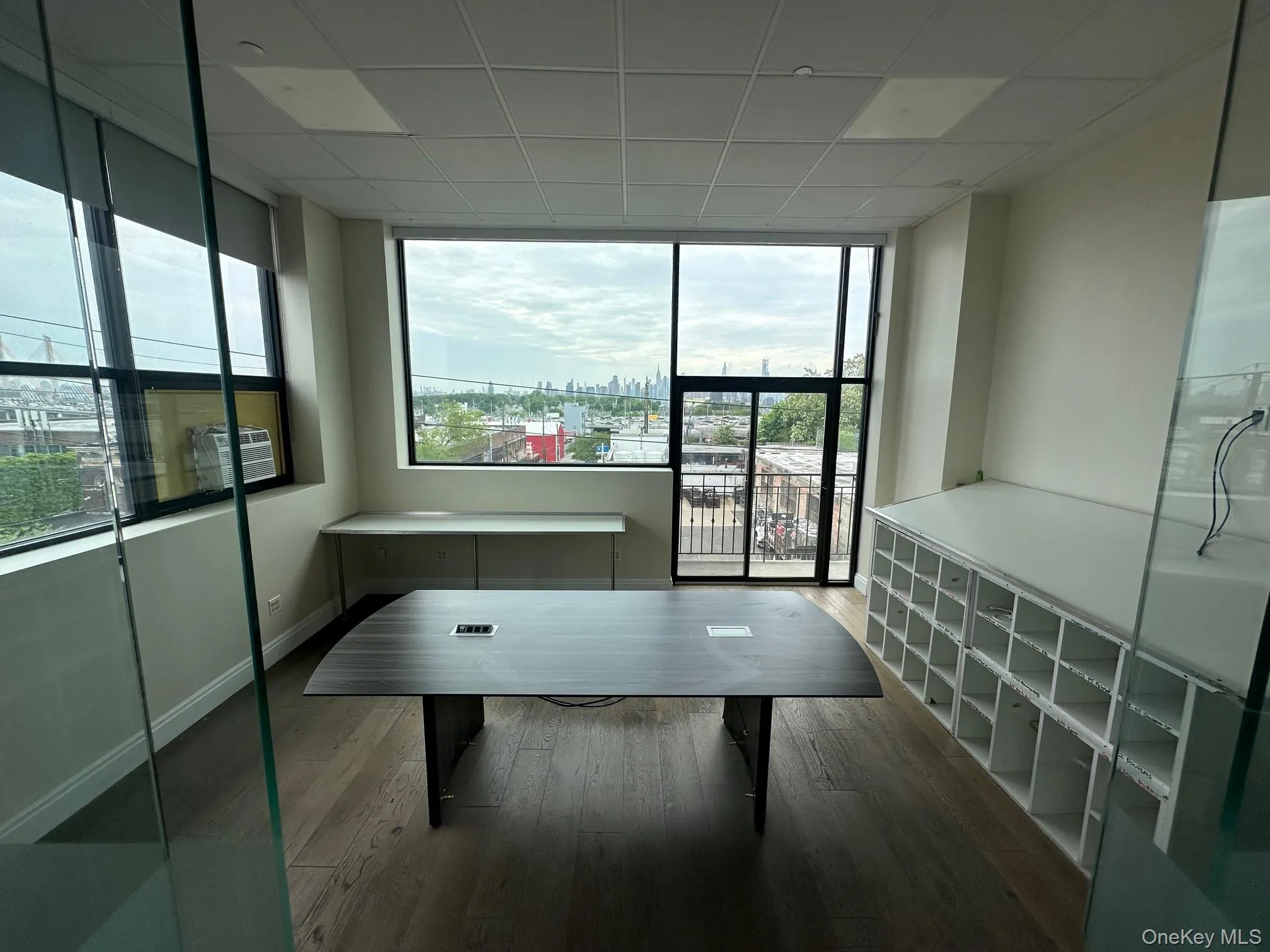 Office area with floor to ceiling windows, dark wood-style flooring, and a paneled ceiling Office area with floor to ceiling windows, dark wood-style flooring, and a paneled ceiling