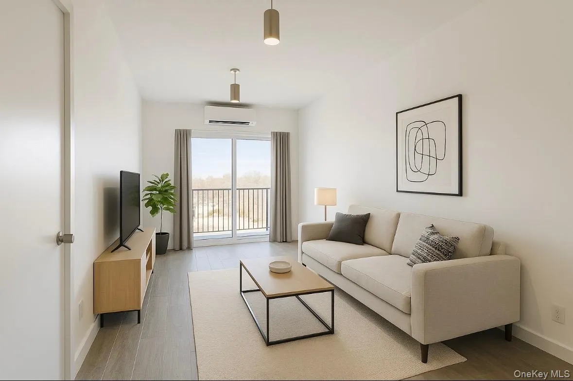 Living area featuring wood finished floors and a wall mounted air conditioner Living area featuring wood finished floors and a wall mounted air conditioner