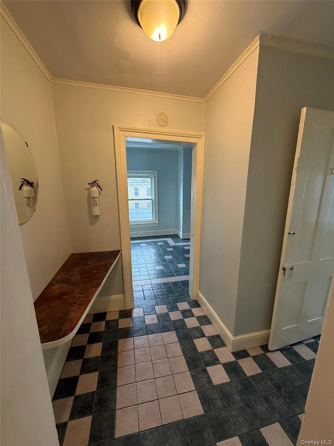 Hallway with dark tile patterned floors and ornamental molding Hallway with dark tile patterned floors and ornamental molding