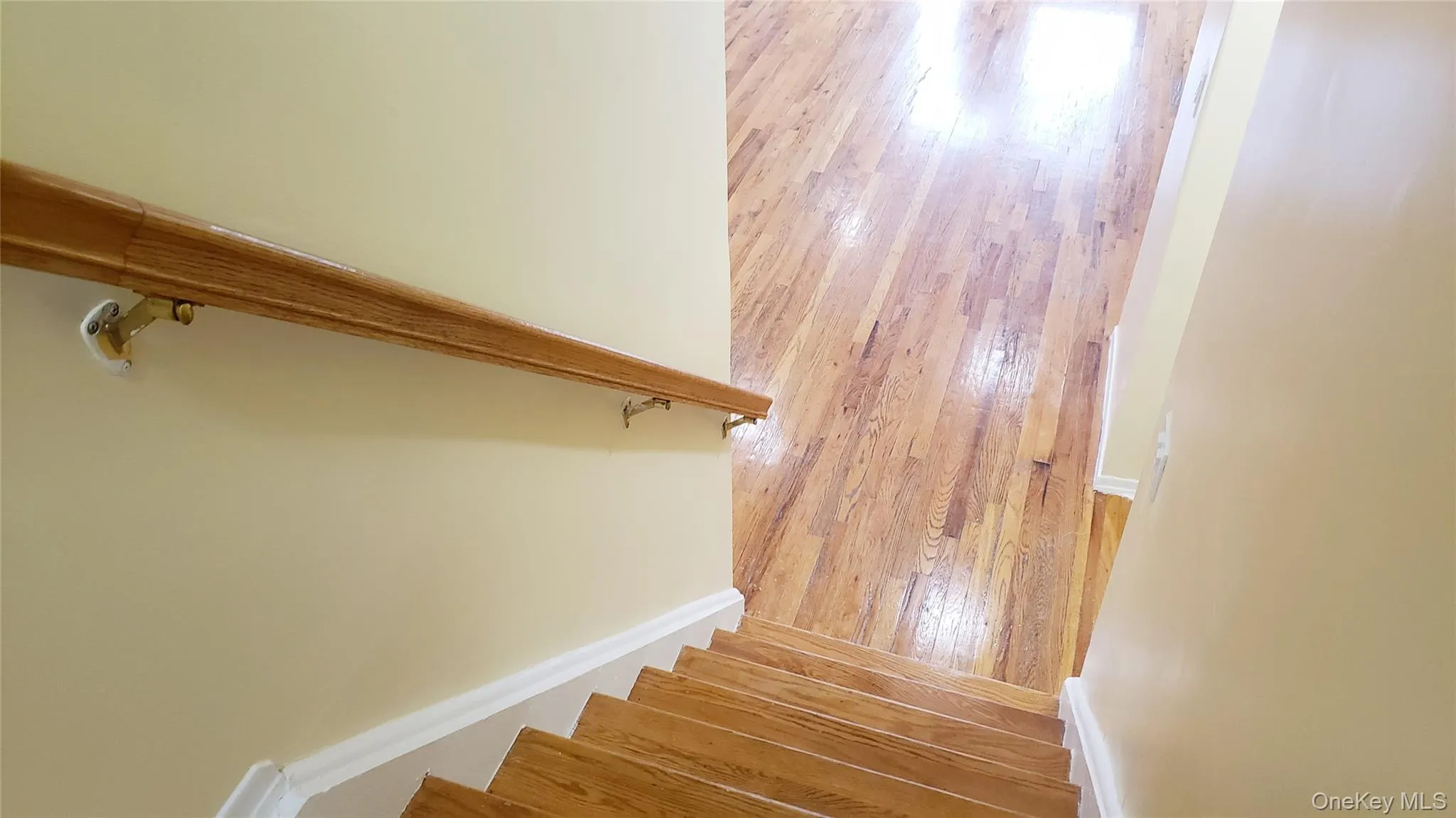 Staircase featuring hardwood / wood-style flooring and baseboards Staircase featuring hardwood / wood-style flooring and baseboards