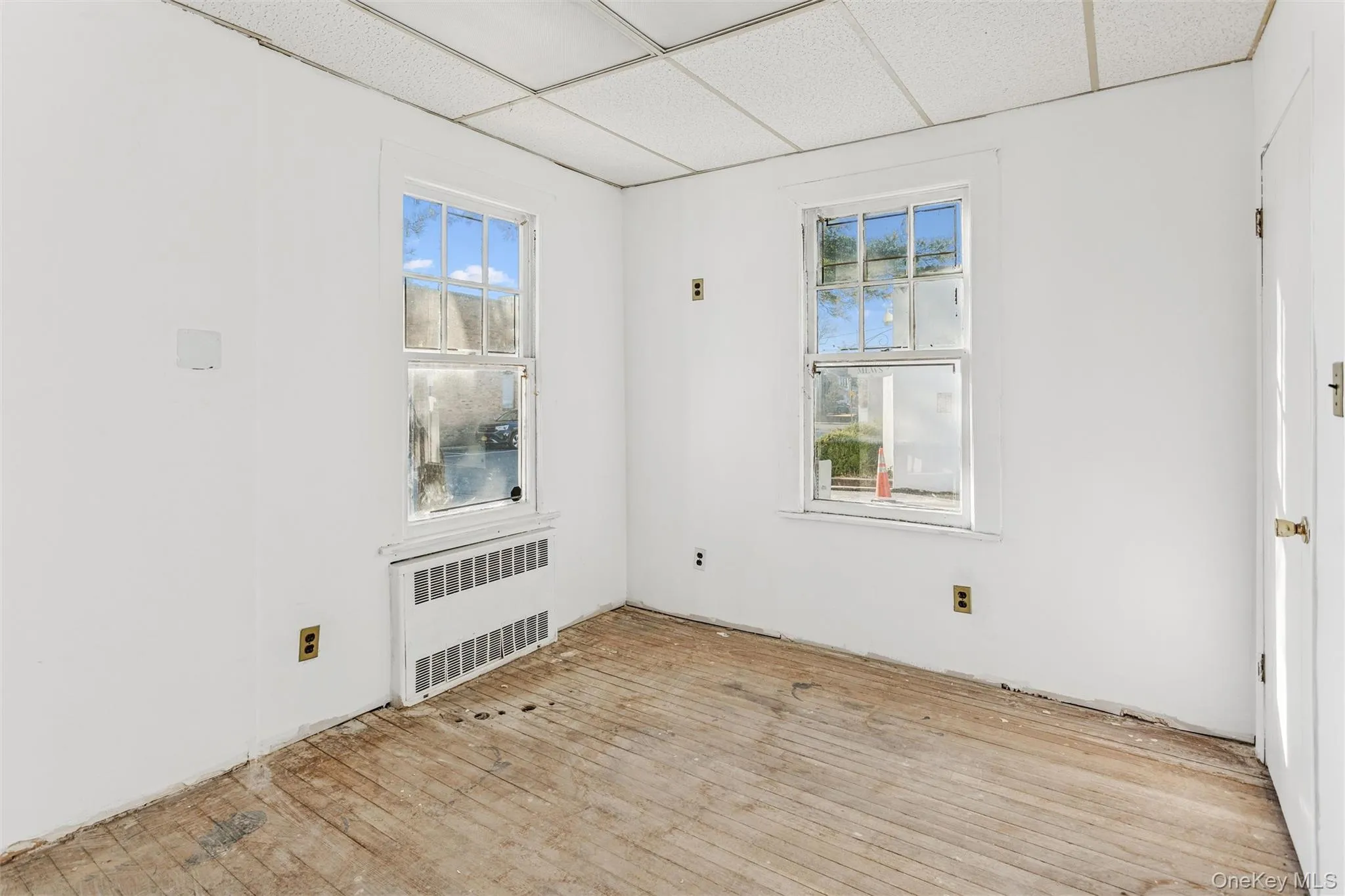 Unfurnished room featuring a paneled ceiling and radiator heating unit Unfurnished room featuring a paneled ceiling and radiator heating unit