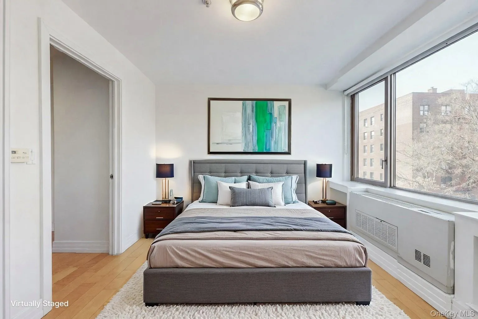 Bedroom featuring radiator heating unit and light wood-style flooring Bedroom featuring radiator heating unit and light wood-style flooring
