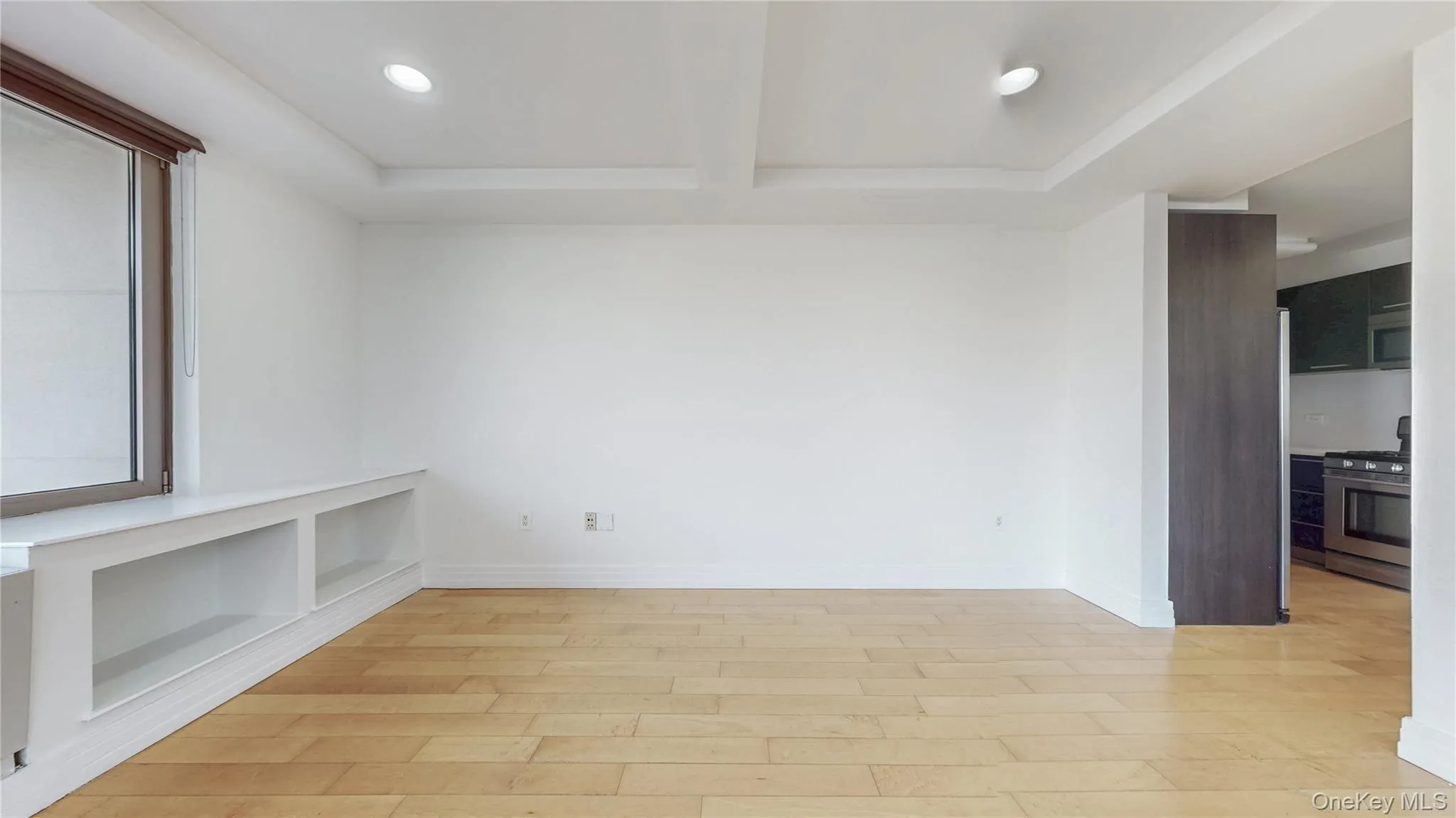 Empty room featuring recessed lighting, light wood-style floors, beamed ceiling, and coffered ceiling Empty room featuring recessed lighting, light wood-style floors, beamed ceiling, and coffered ceiling