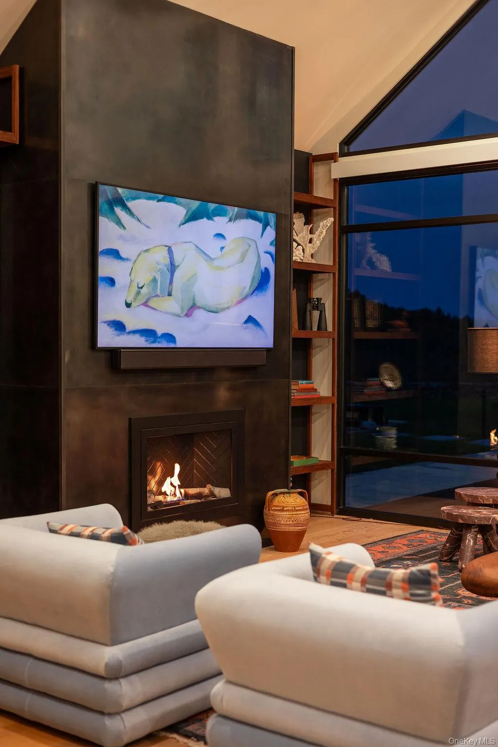 Living area with a large fireplace, vaulted ceiling, and wood finished floors Living area with a large fireplace, vaulted ceiling, and wood finished floors