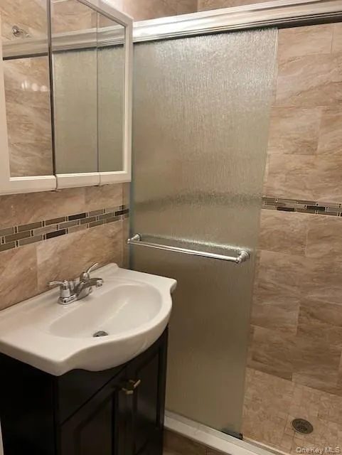 Bathroom featuring vanity and a tile shower Bathroom featuring vanity and a tile shower