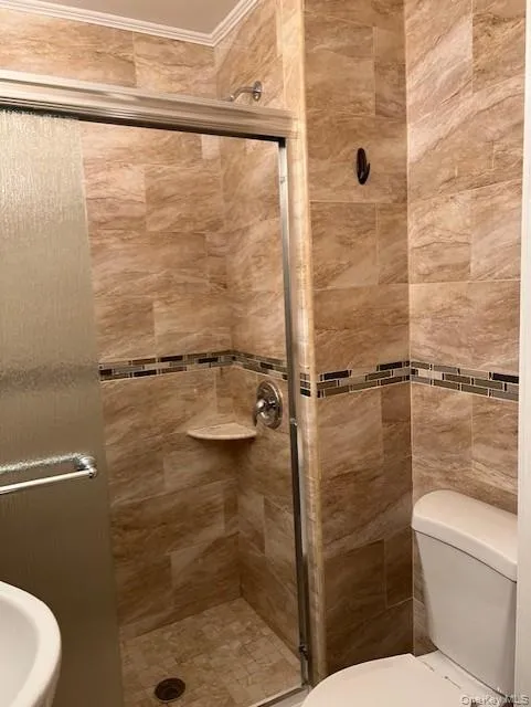 Full bathroom with a shower stall and crown molding Full bathroom with a shower stall and crown molding