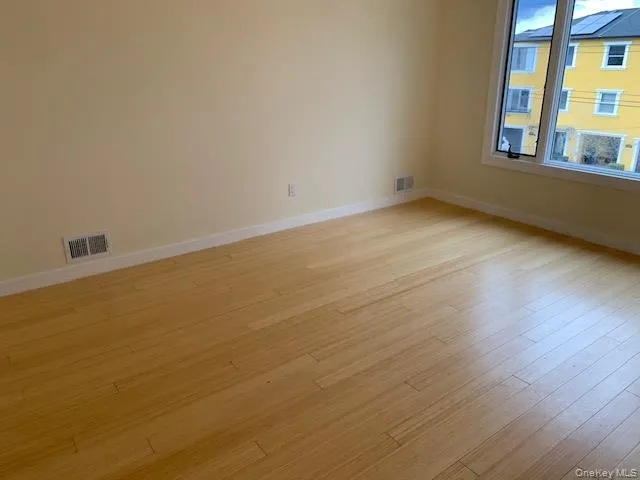 Unfurnished room with baseboards and light wood finished floors Unfurnished room with baseboards and light wood finished floors