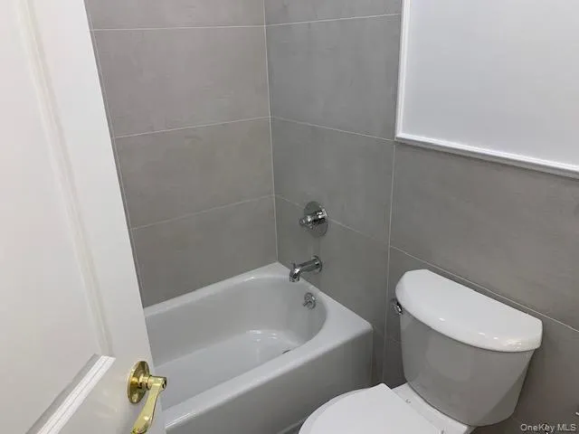 Bathroom with tile walls and bathtub / shower combination Bathroom with tile walls and bathtub / shower combination