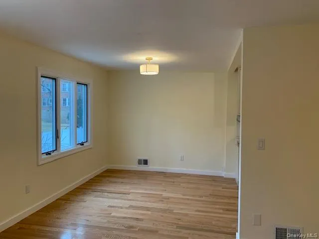 Empty room with light wood-style floors and baseboards Empty room with light wood-style floors and baseboards