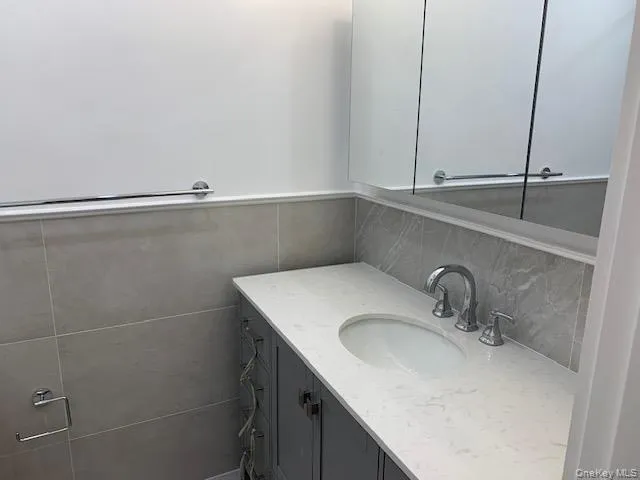 Half bath with vanity and tile walls Half bath with vanity and tile walls