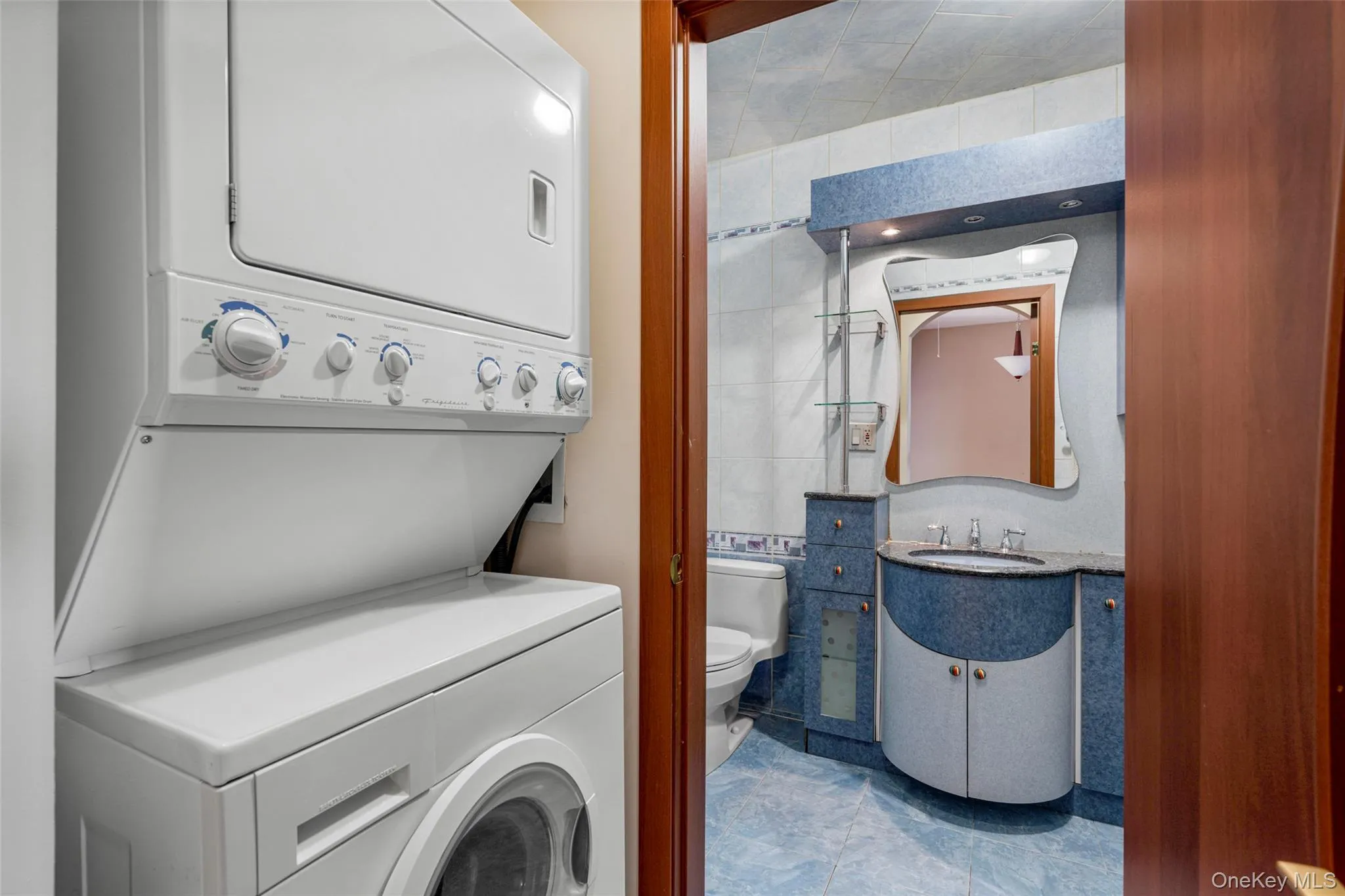 Washroom with estacked washer and dryer and tile walls Washroom with estacked washer and dryer and tile walls