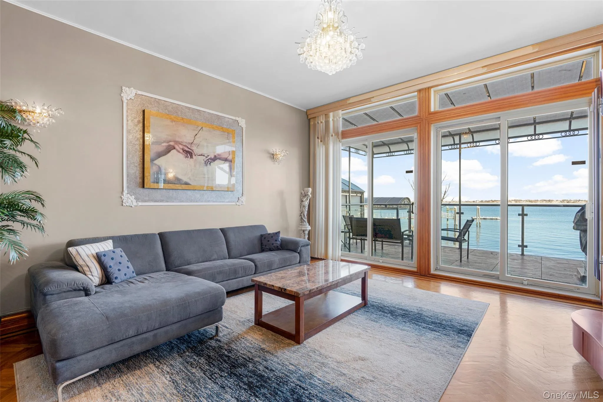 Living room with a water view, a chandelier, and crown molding Living room with a water view, a chandelier, and crown molding