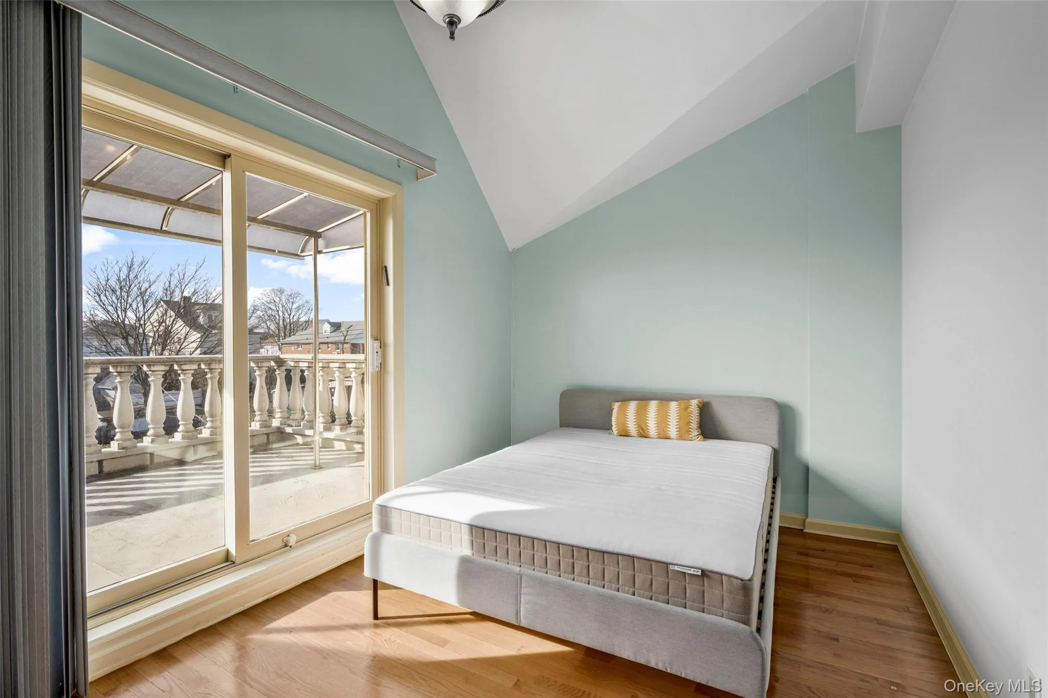 Bedroom with access to exterior, lofted ceiling, and wood finished floors Bedroom with access to exterior, lofted ceiling, and wood finished floors