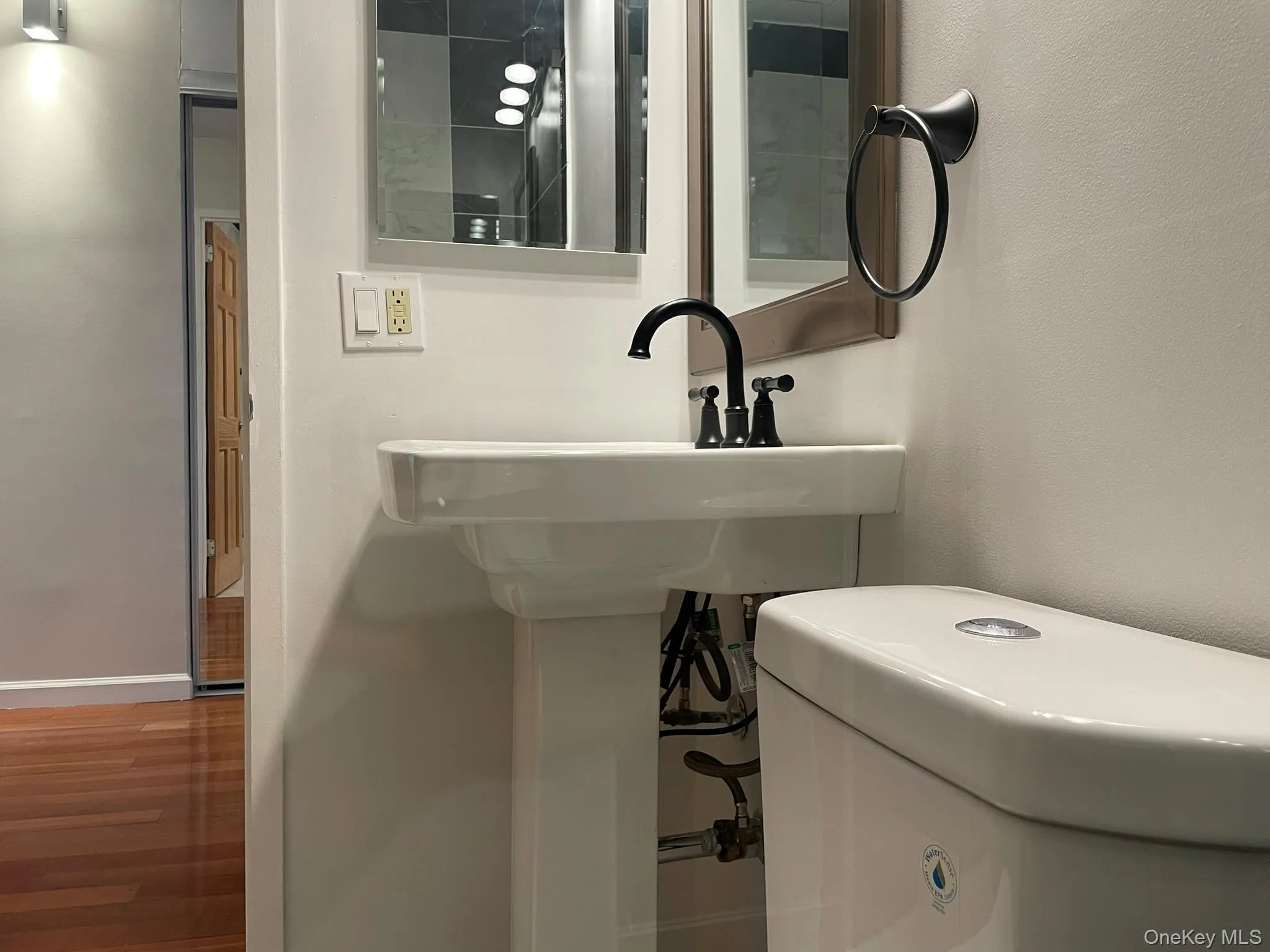 Half bath featuring baseboards and wood finished floors Half bath featuring baseboards and wood finished floors