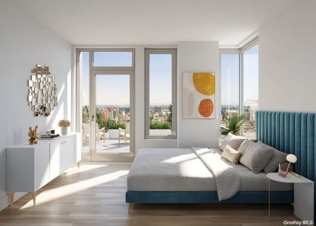 Bedroom with expansive windows, wood finished floors, radiator, and access to exterior Bedroom with expansive windows, wood finished floors, radiator, and access to exterior