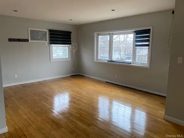 Empty room with baseboards and light wood-style floors Empty room with baseboards and light wood-style floors