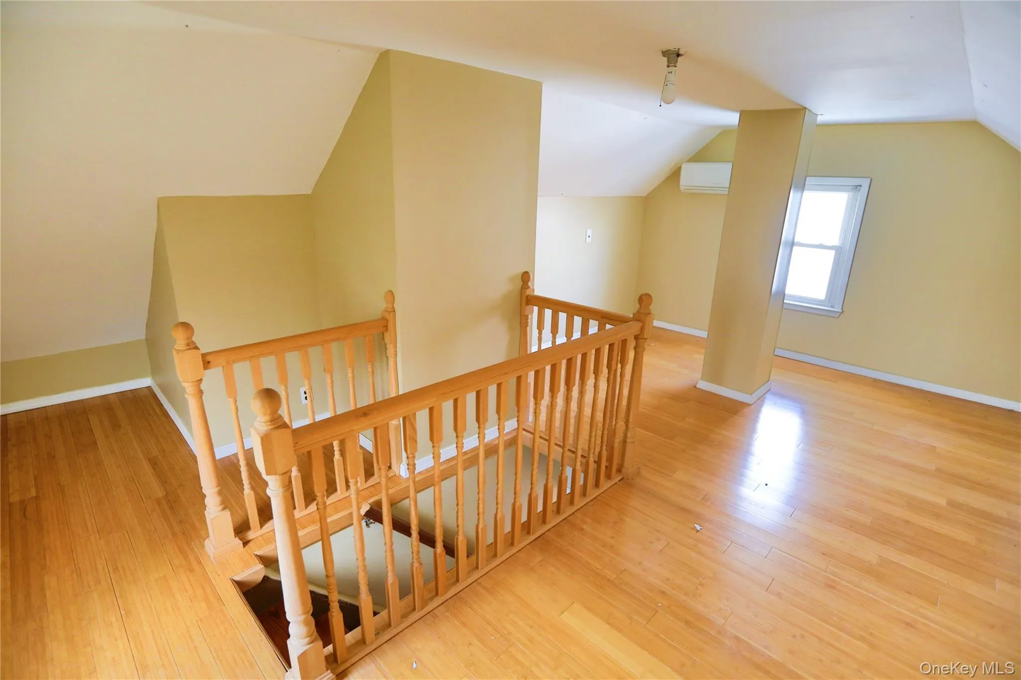 Stairway with wood finished floors and a wall mounted AC Stairway with wood finished floors and a wall mounted AC