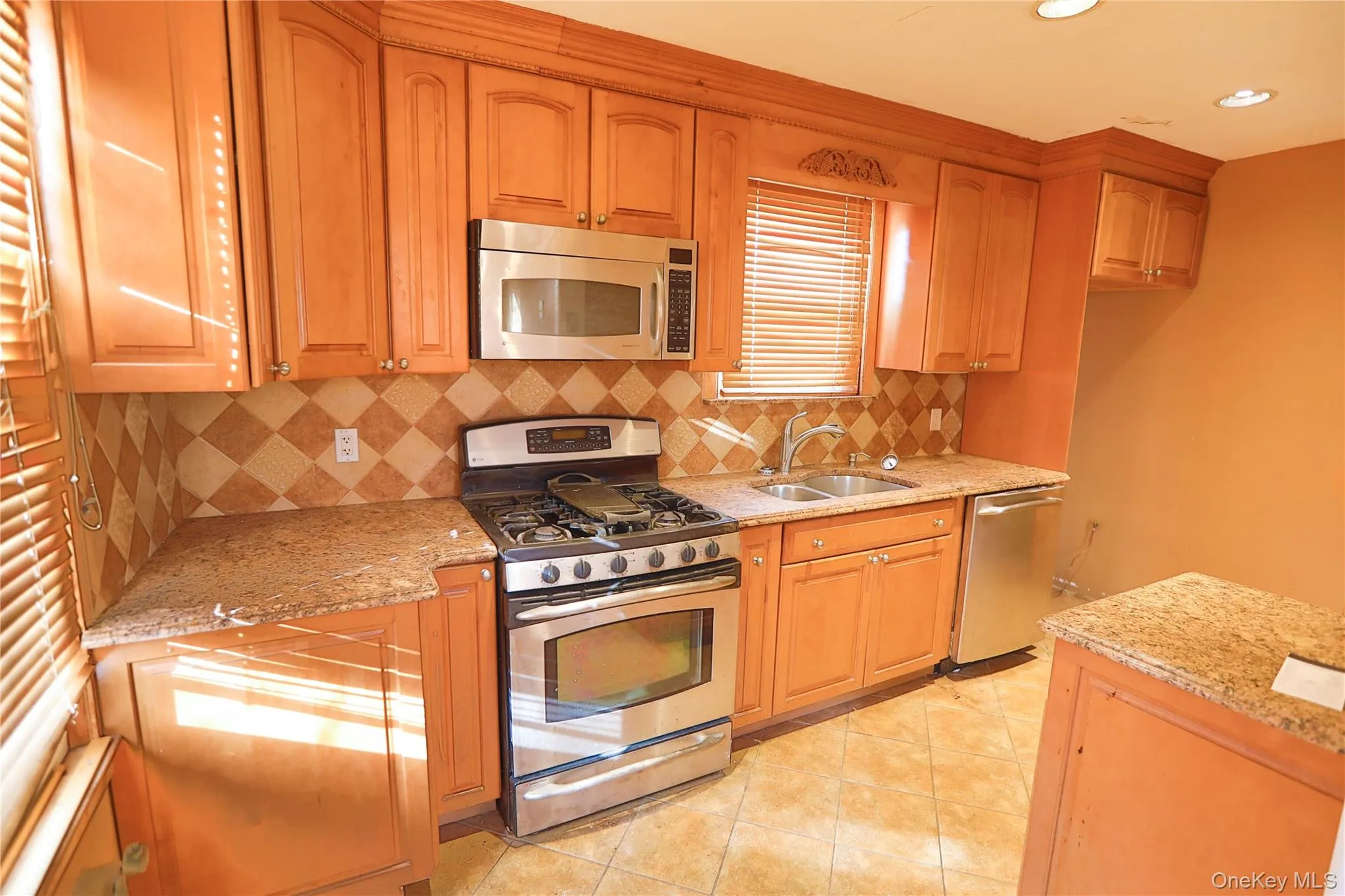 Kitchen featuring stainless steel appliances, light stone countertops, tasteful backsplash, light tile patterned floors, and recessed lighting Kitchen featuring stainless steel appliances, light stone countertops, tasteful backsplash, light tile patterned floors, and recessed lighting