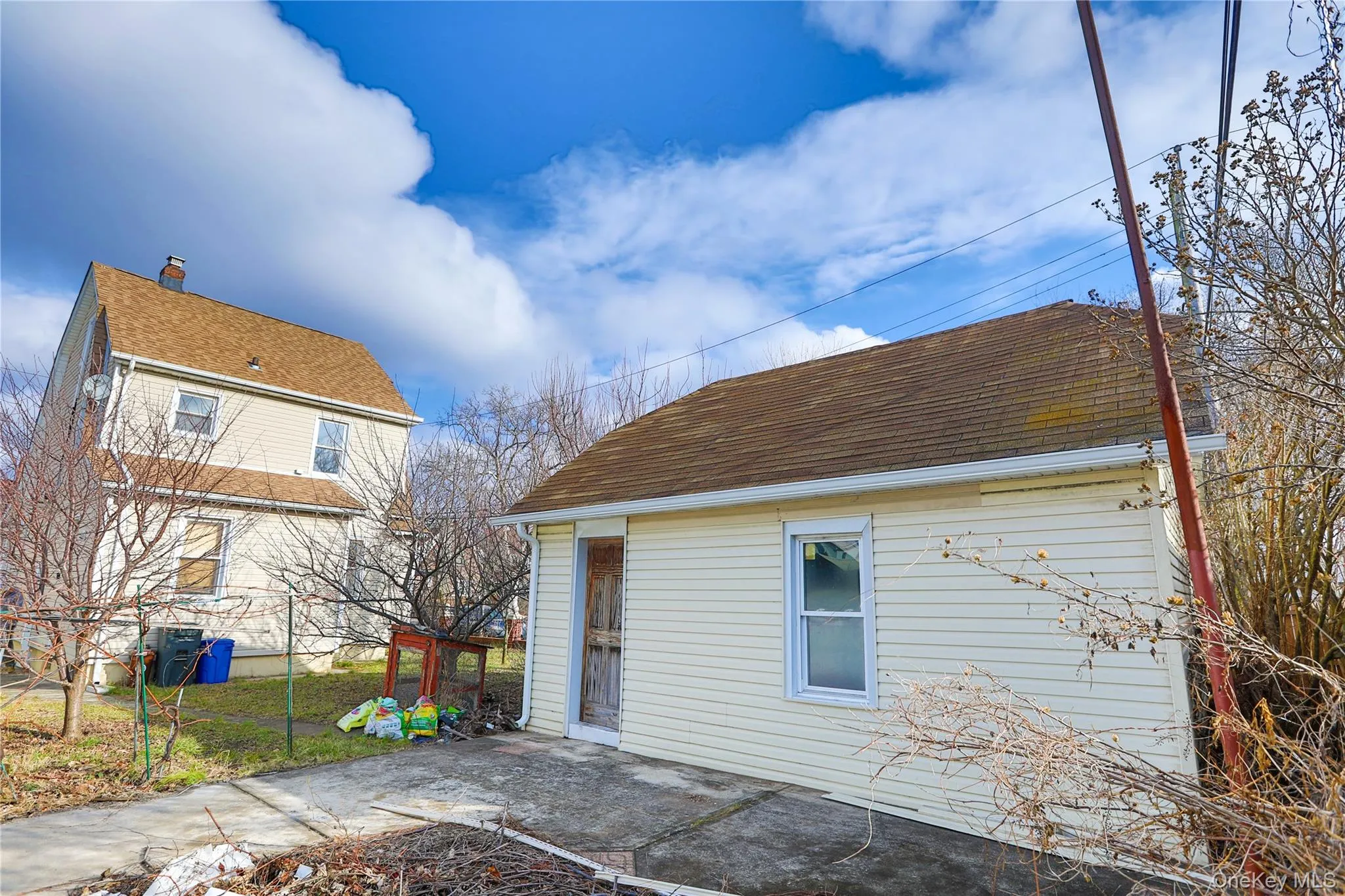 Rear view of house featuring a patio area and a shingled roof Rear view of house featuring a patio area and a shingled roof