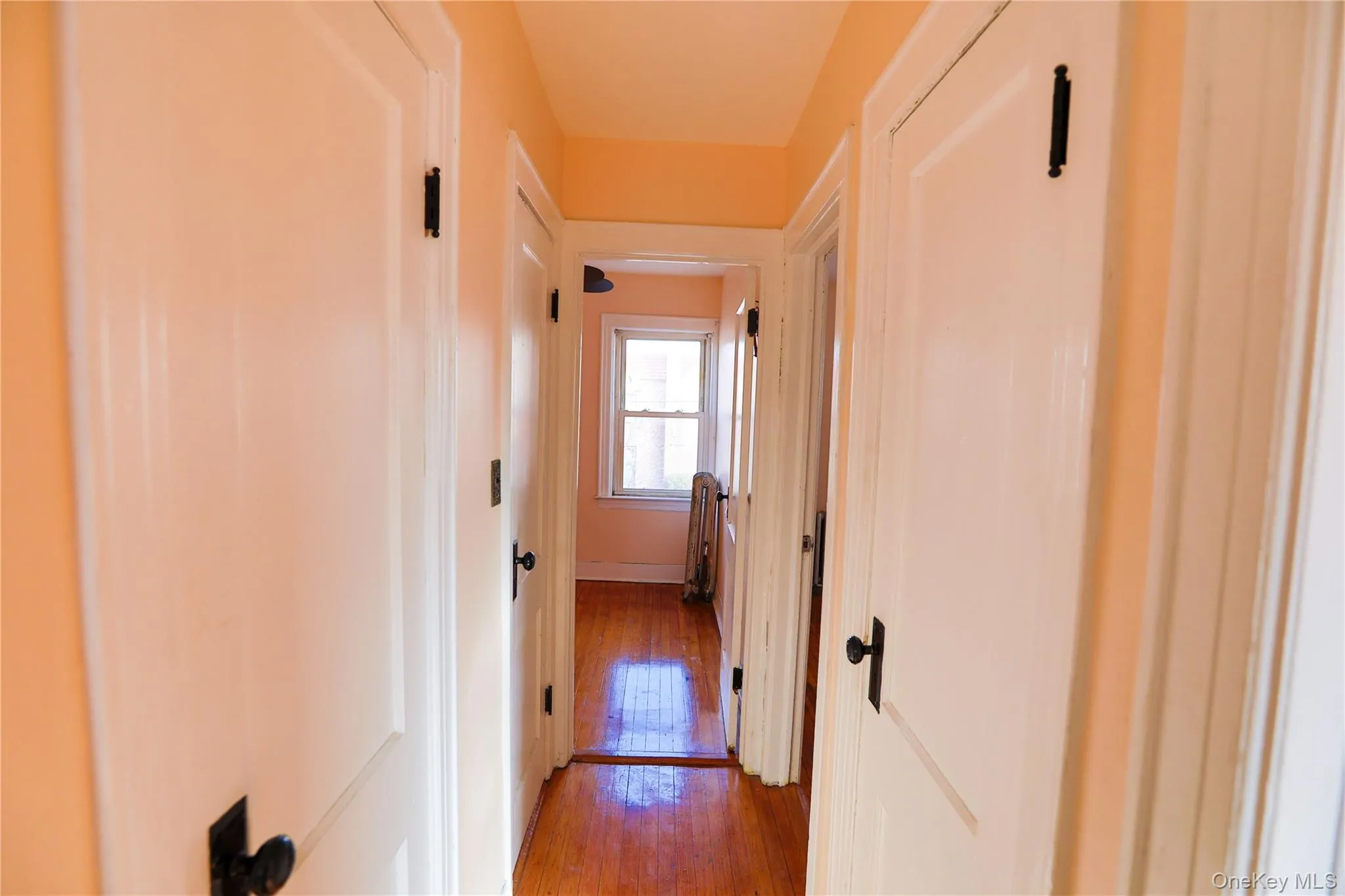 Corridor with hardwood / wood-style floors and baseboards Corridor with hardwood / wood-style floors and baseboards