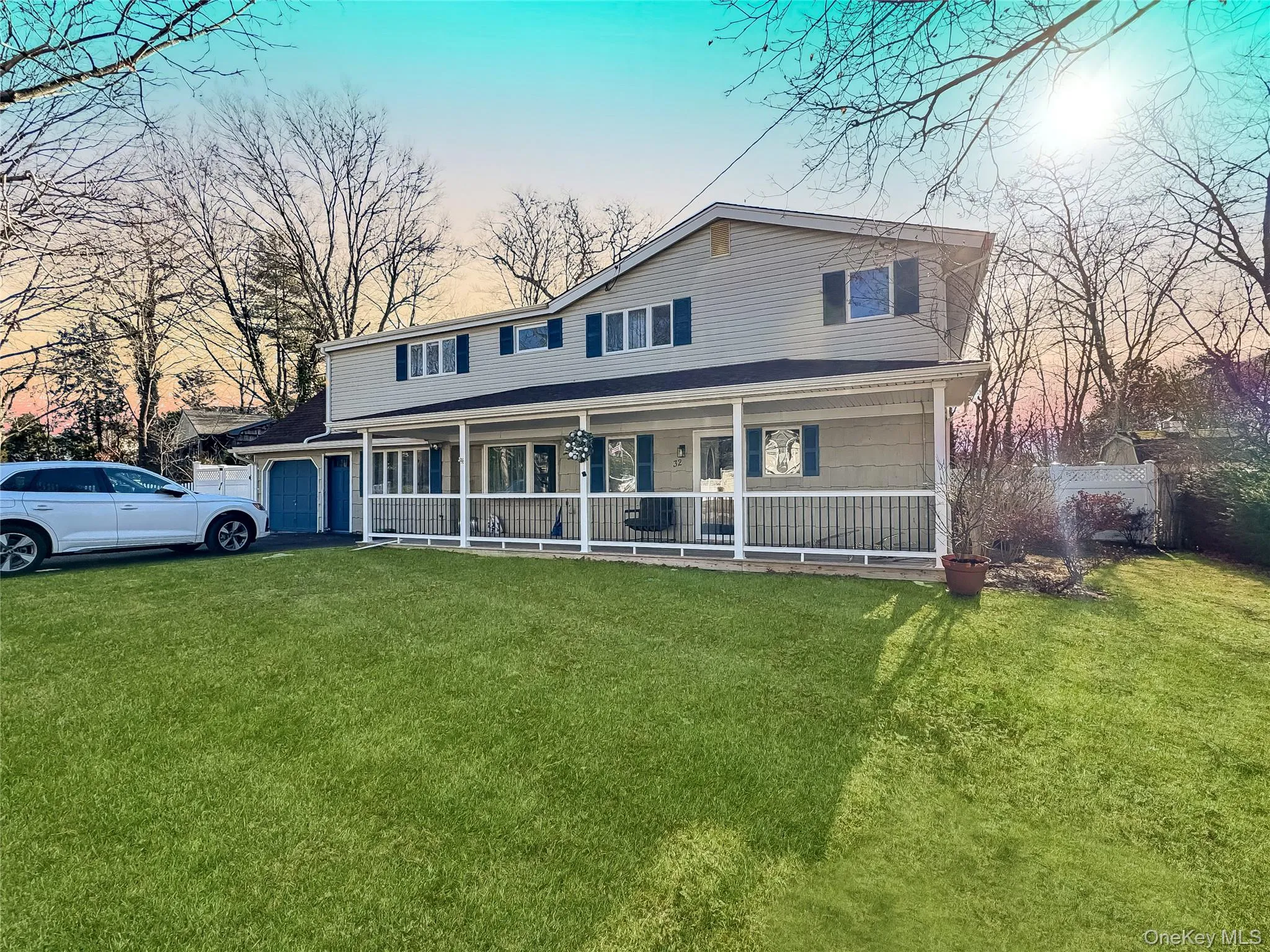 View of front of home featuring a front lawn, a porch, and a garage View of front of home featuring a front lawn, a porch, and a garage