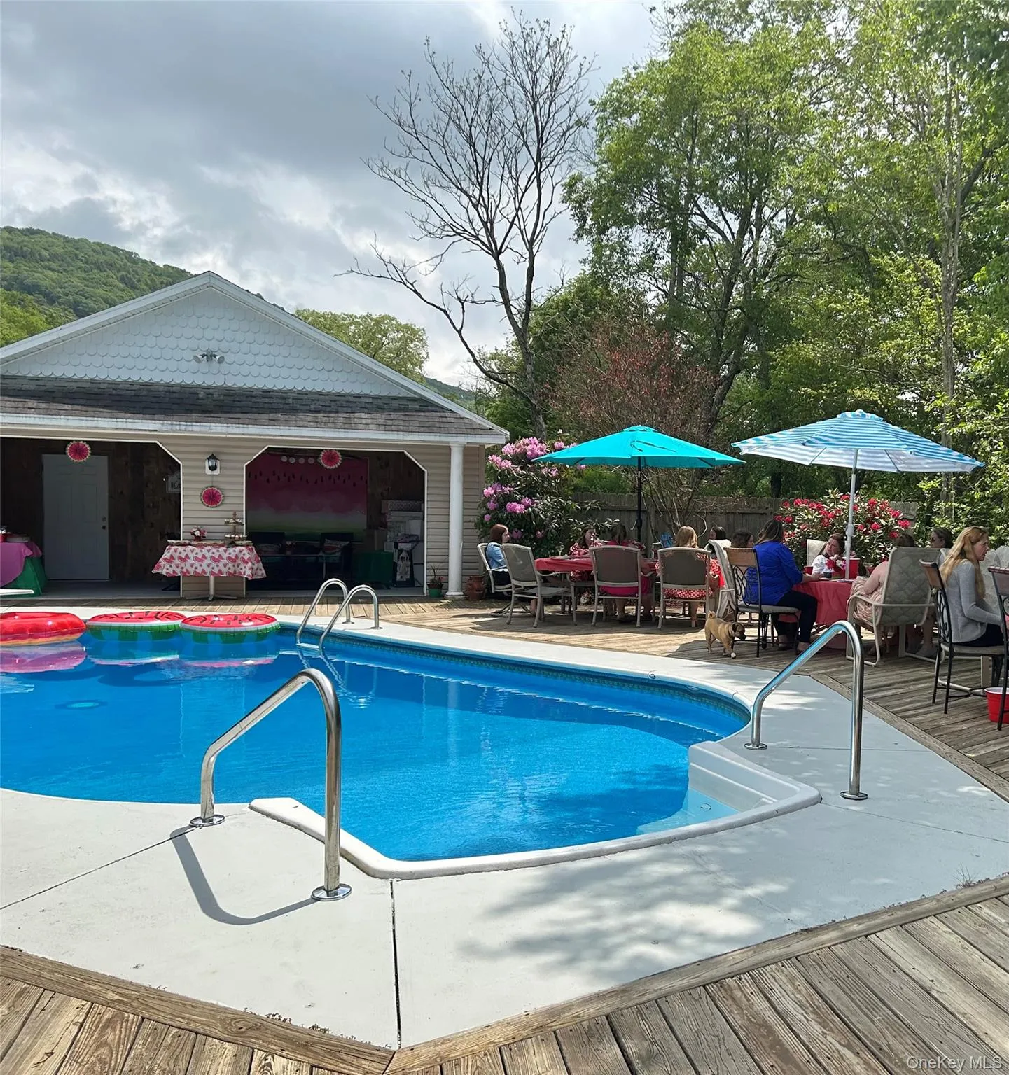 Outdoor pool with a patio, an outdoor structure, outdoor dining area, and a storage structure Outdoor pool with a patio, an outdoor structure, outdoor dining area, and a storage structure