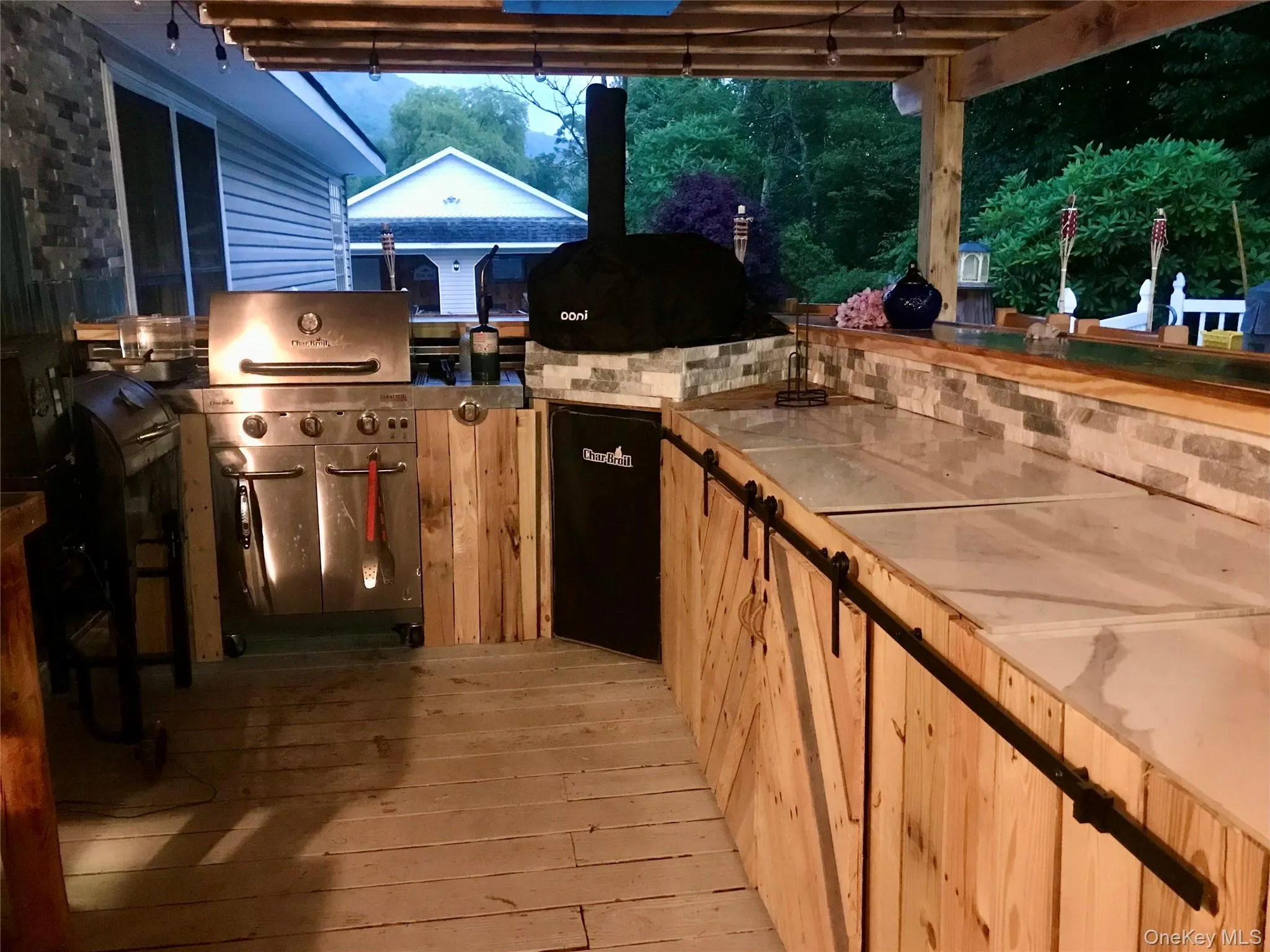 View of patio featuring area for grilling and a wooden deck View of patio featuring area for grilling and a wooden deck