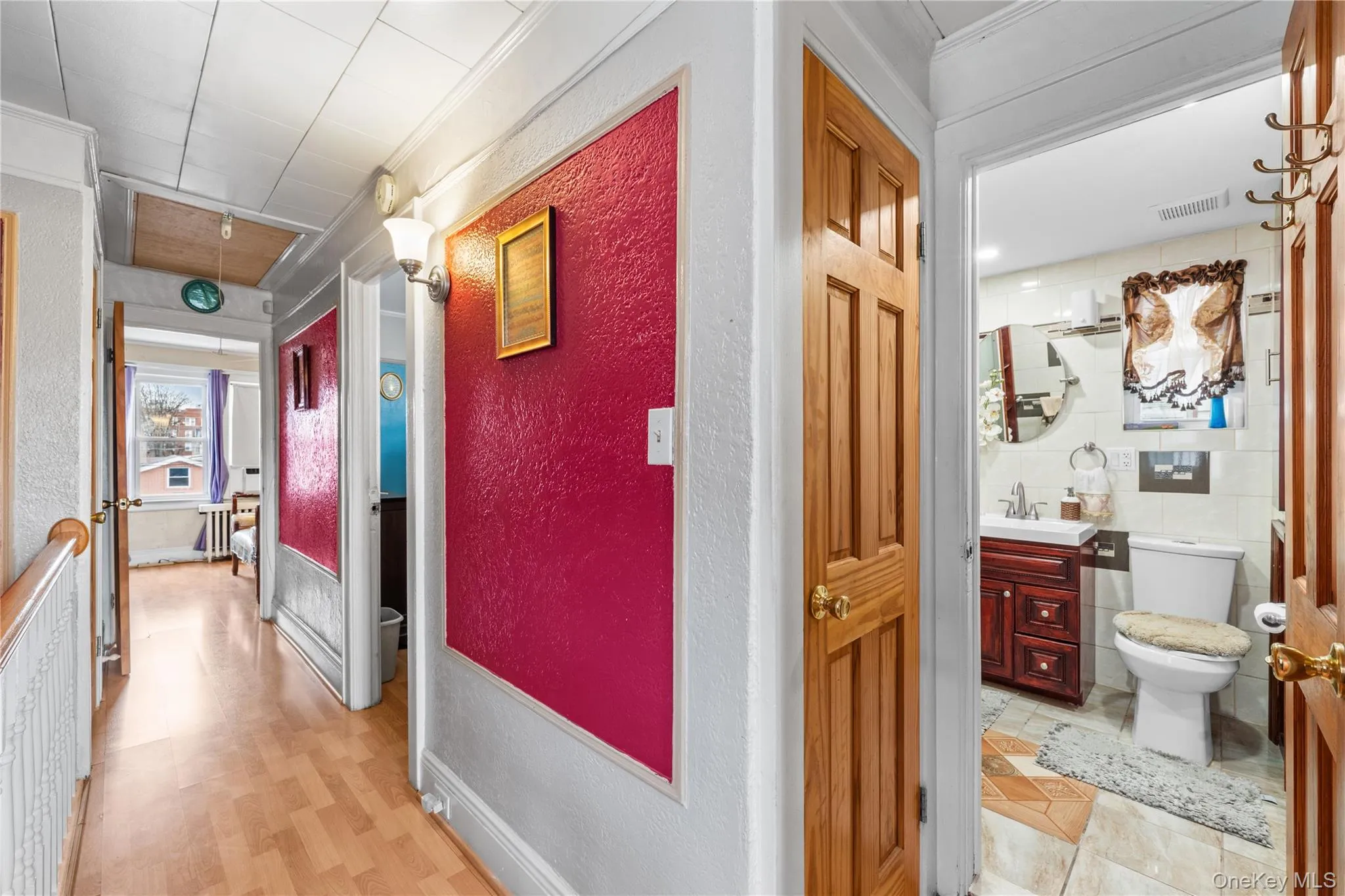 Corridor with attic access, a textured wall, and ornamental molding Corridor with attic access, a textured wall, and ornamental molding