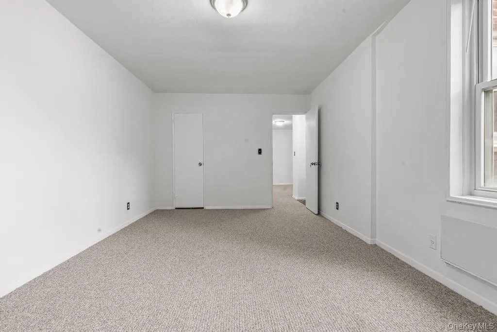Carpeted spare room featuring baseboards Carpeted spare room featuring baseboards