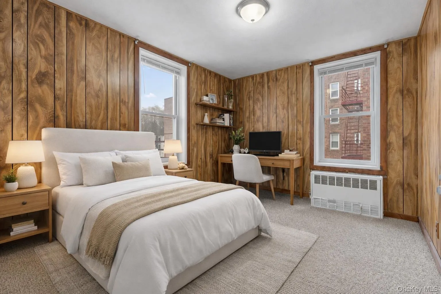 Virtually staged. Bedroom with radiator heating unit, light carpet, wooden walls, and a desk Virtually staged. Bedroom with radiator heating unit, light carpet, wooden walls, and a desk