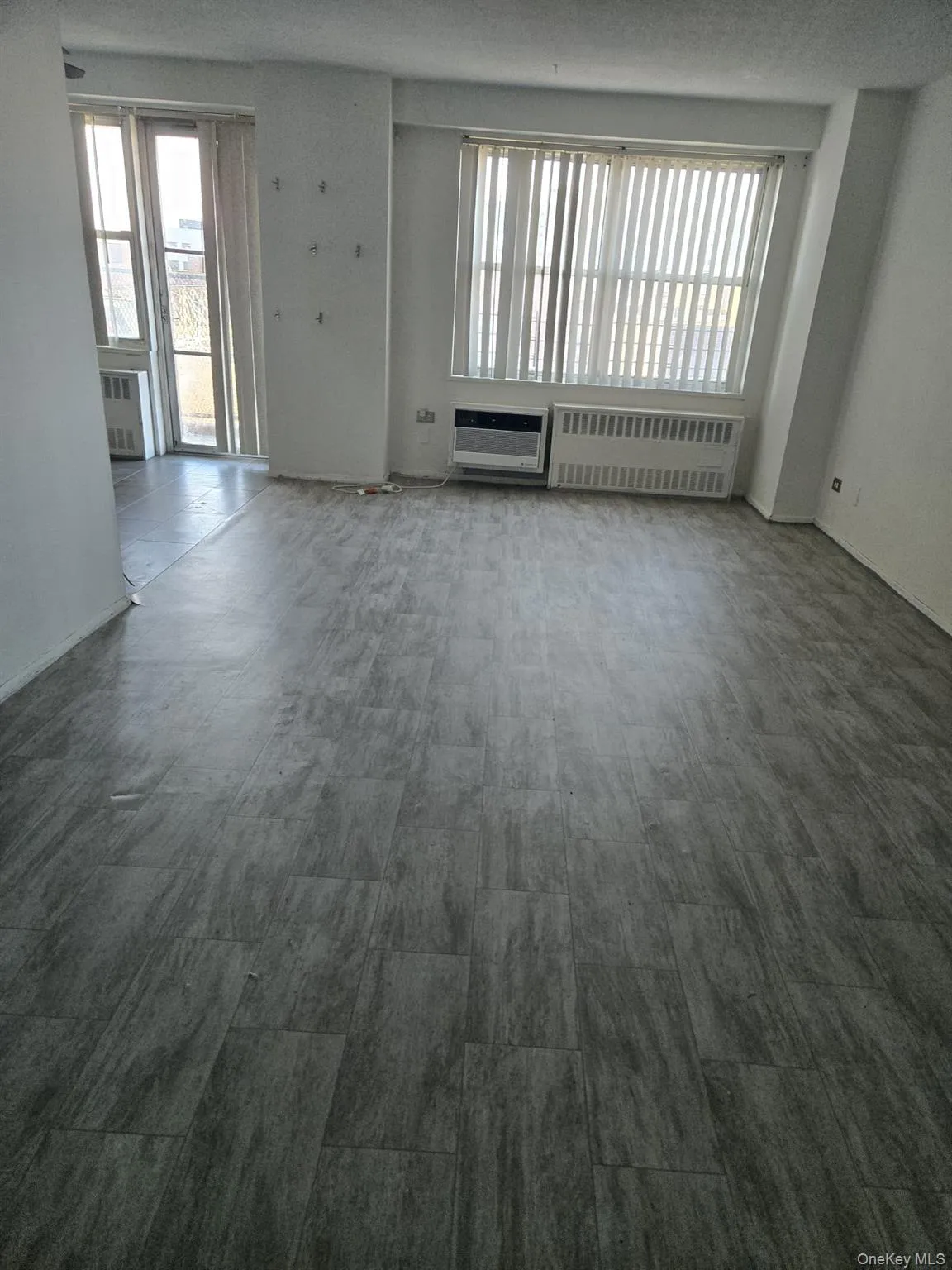Unfurnished room with radiator and plenty of natural light Unfurnished room with radiator and plenty of natural light