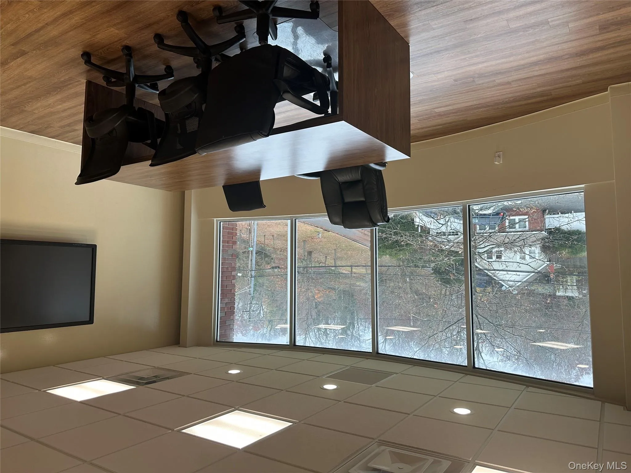 Office space featuring wood finished floors and a drop ceiling Office space featuring wood finished floors and a drop ceiling