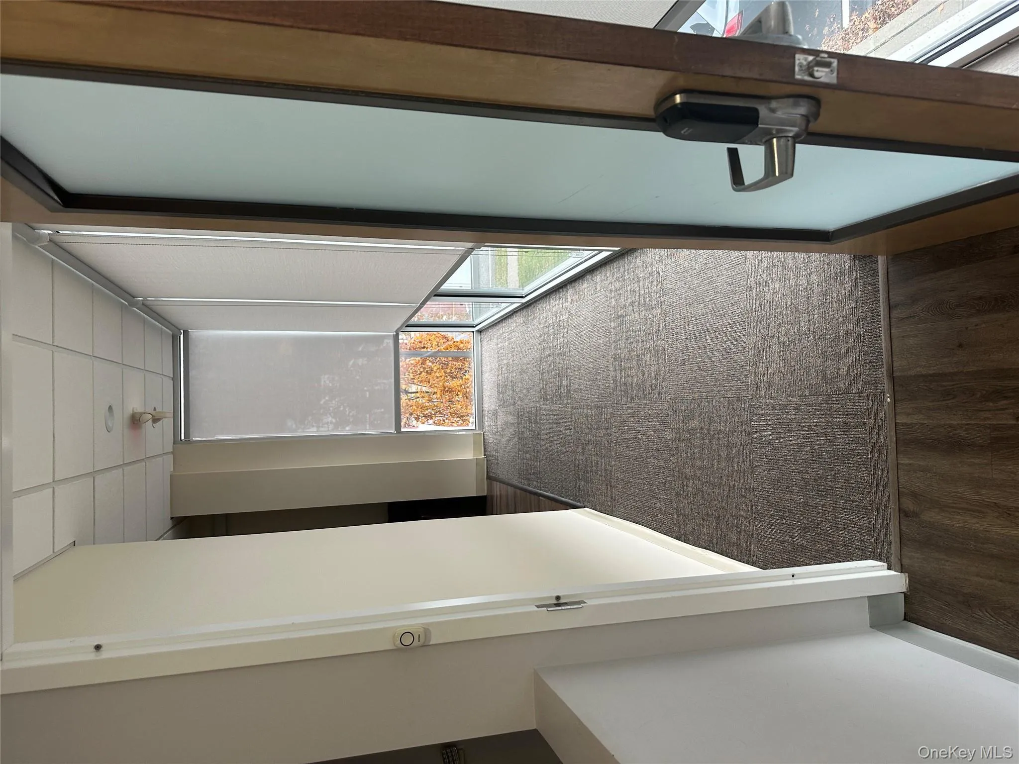 Hallway with plenty of natural light, a paneled ceiling, dark colored carpet, and dark wood-type flooring Hallway with plenty of natural light, a paneled ceiling, dark colored carpet, and dark wood-type flooring
