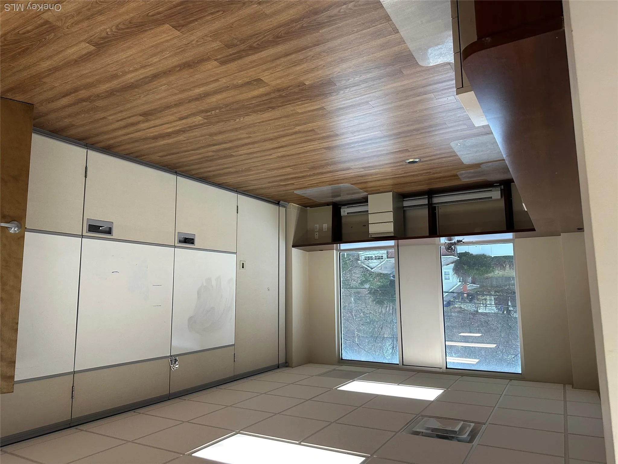 Unfurnished room featuring wood finished floors, a paneled ceiling, and a baseboard radiator Unfurnished room featuring wood finished floors, a paneled ceiling, and a baseboard radiator