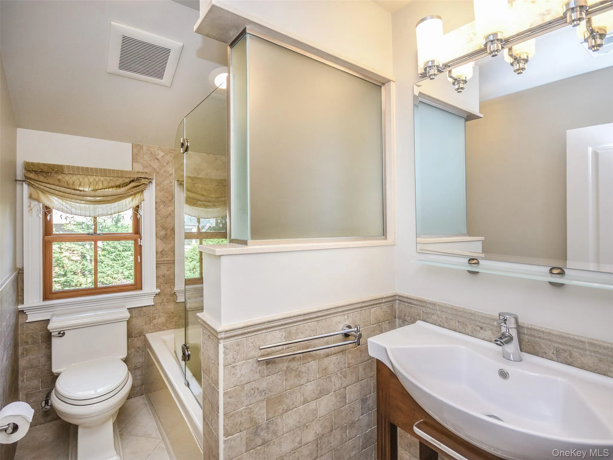 2nd Fl. Full bathroom featuring tile walls, wainscoting, shower / tub combination, and tile patterned flooring 2nd Fl. Full bathroom featuring tile walls, wainscoting, shower / tub combination, and tile patterned flooring