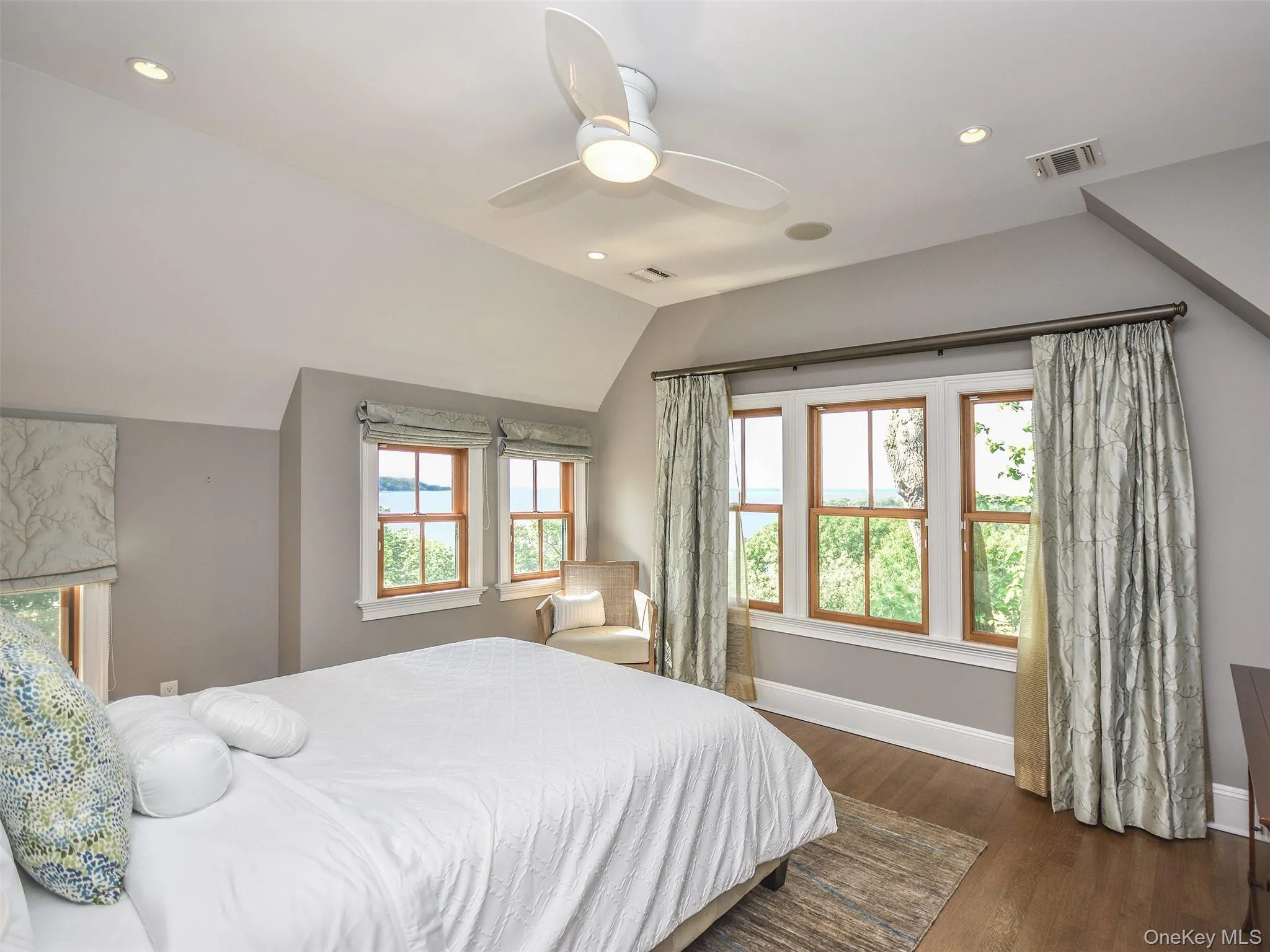 Primary Bedroom with WATER views recessed lighting, lofted ceiling, ceiling fan, and dark wood-style flooring Primary Bedroom with WATER views recessed lighting, lofted ceiling, ceiling fan, and dark wood-style flooring