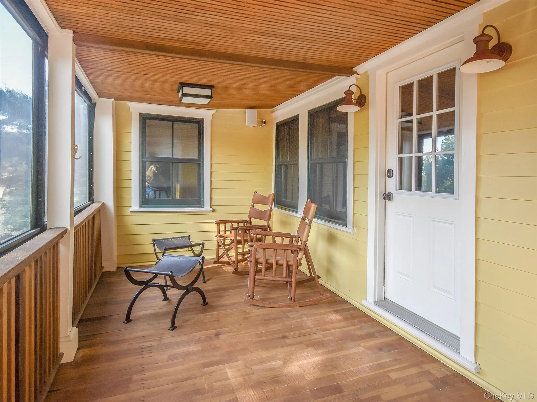 Lower enclosed deck featuring wooden ceiling, wood finished floors. Leads out to the back of the house Lower enclosed deck featuring wooden ceiling, wood finished floors. Leads out to the back of the house